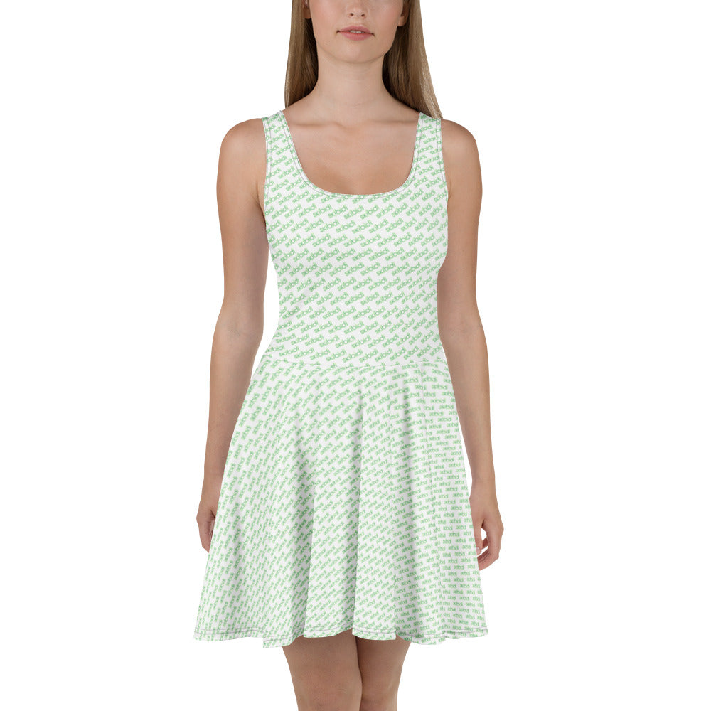 Front view of blonde model in mint green skibidi skater dress, all-over white toilet-head print, flared skirt twirl-ready