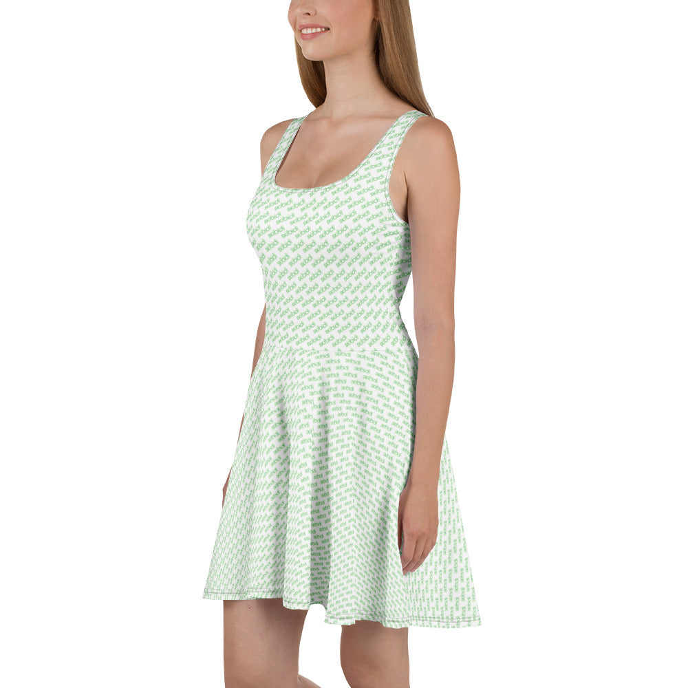 Side view of blonde model in mint green skibidi skater dress, hugging curves with playful white print flare
