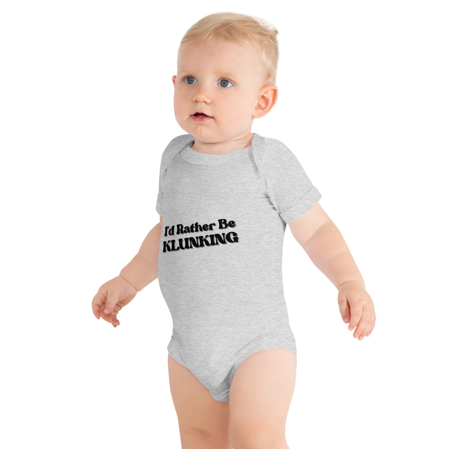 Side profile of baby walking in heather gray "I’d Rather Be KLUNKING" baby onesie