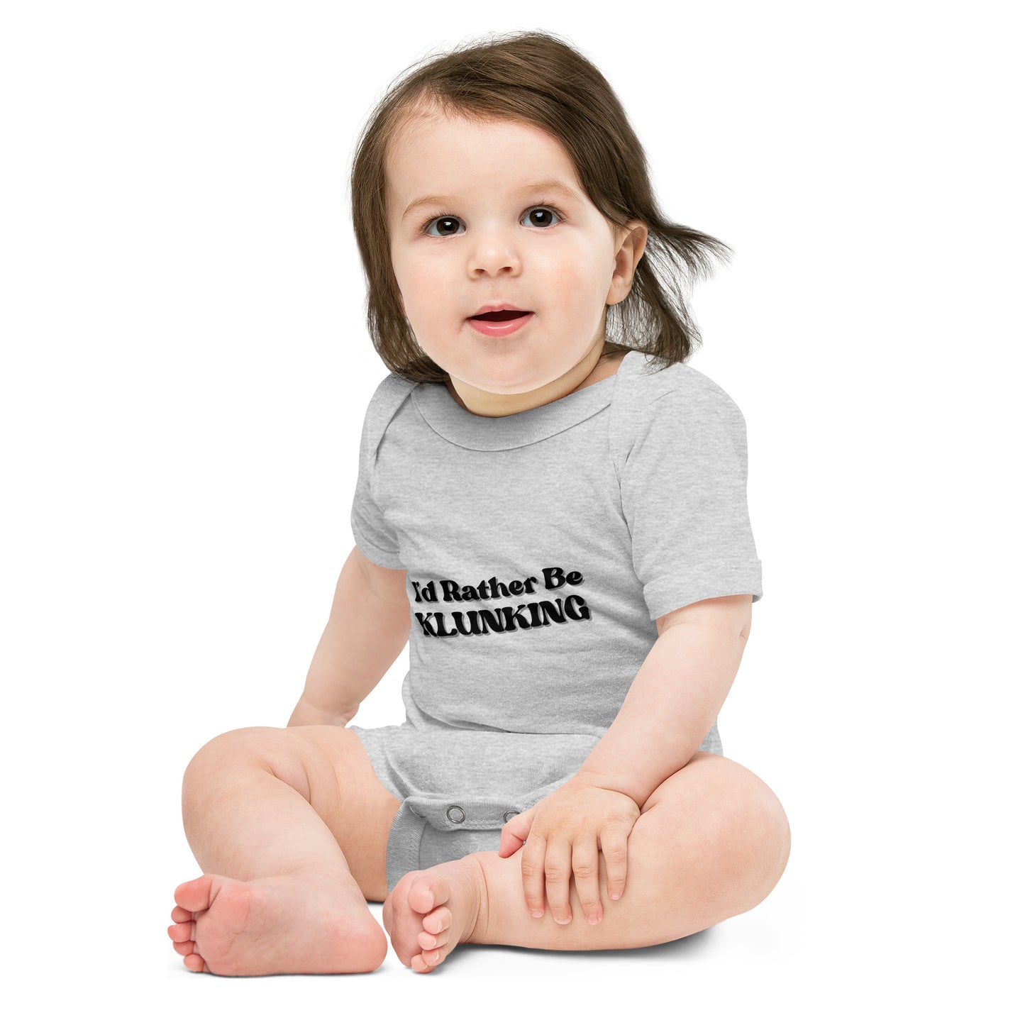 Smiley baby sitting front-on in heather gray "I’d Rather Be Klunking" short sleeve onesie