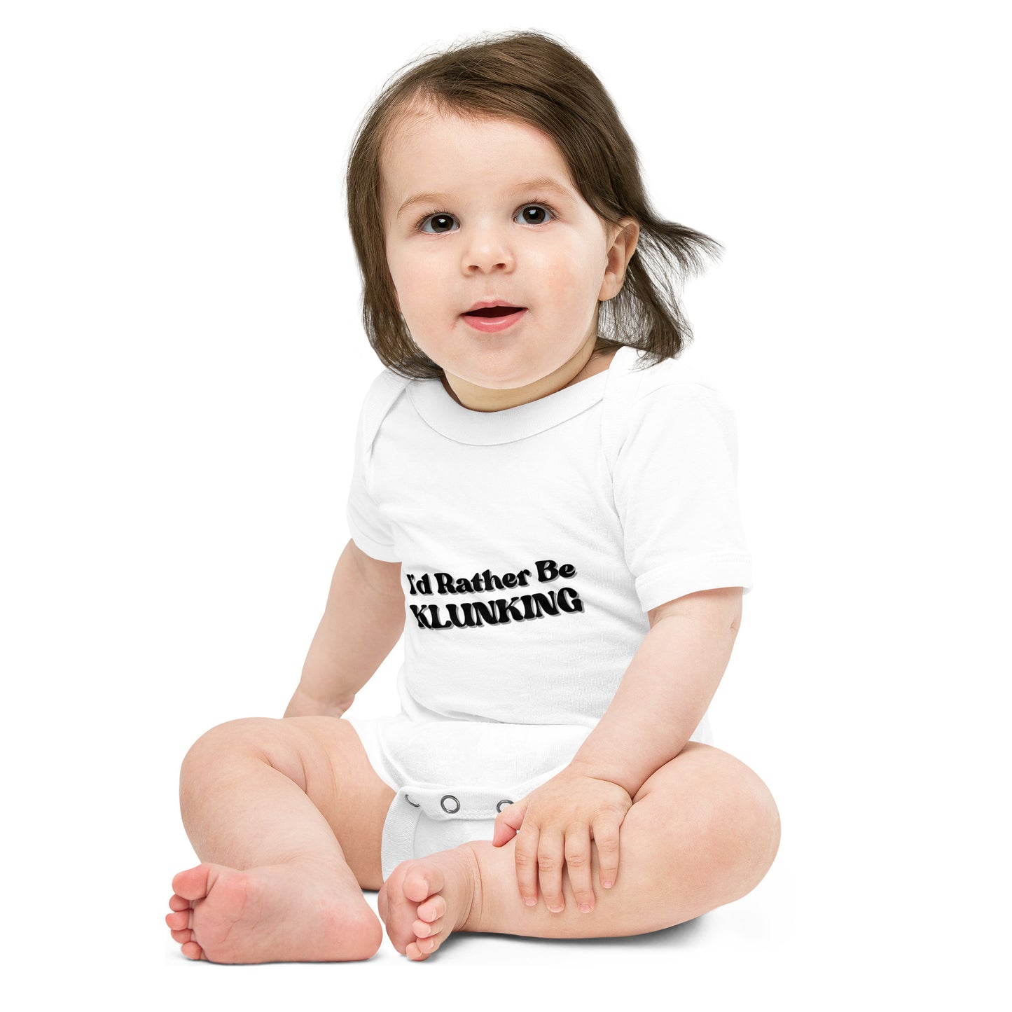Baby model sitting in white "I’d Rather Be Klunking" short sleeve onesie, front view with black text