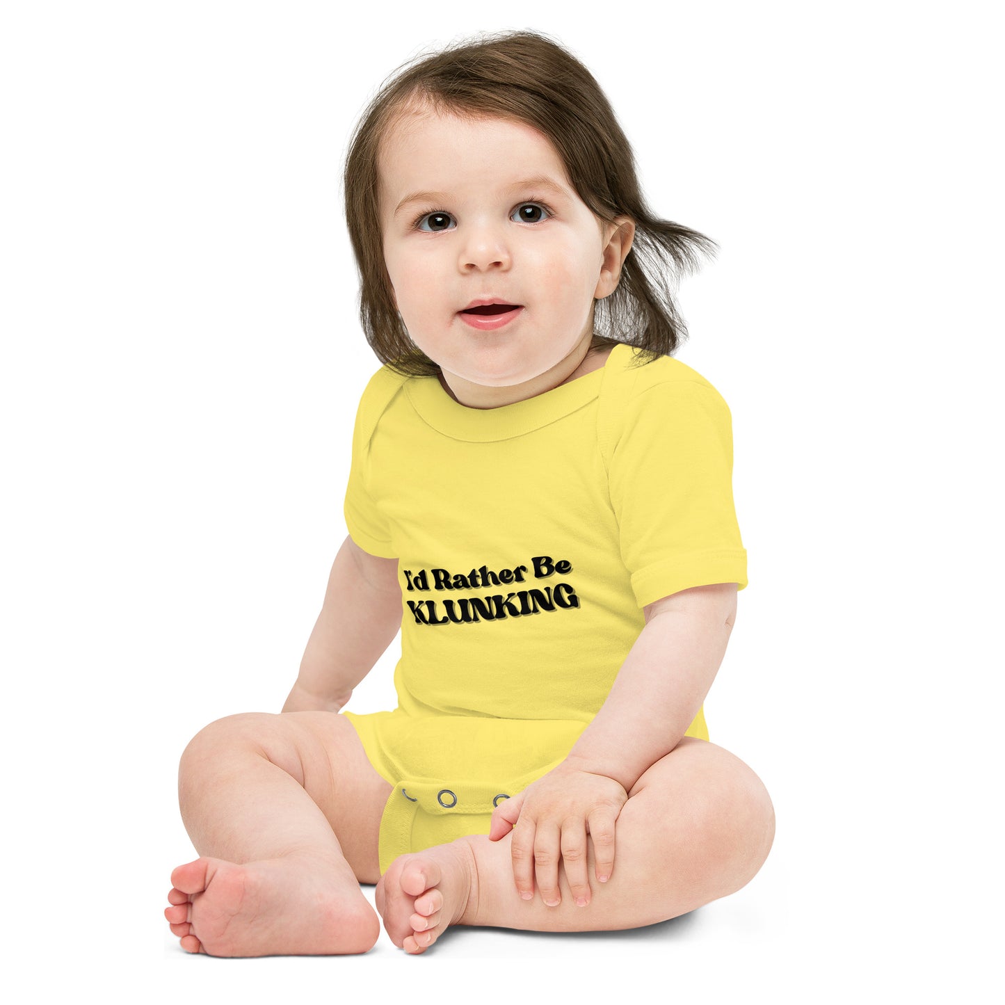 Baby model sitting in yellow "I’d Rather Be Klunking" short sleeve onesie, front view with black text