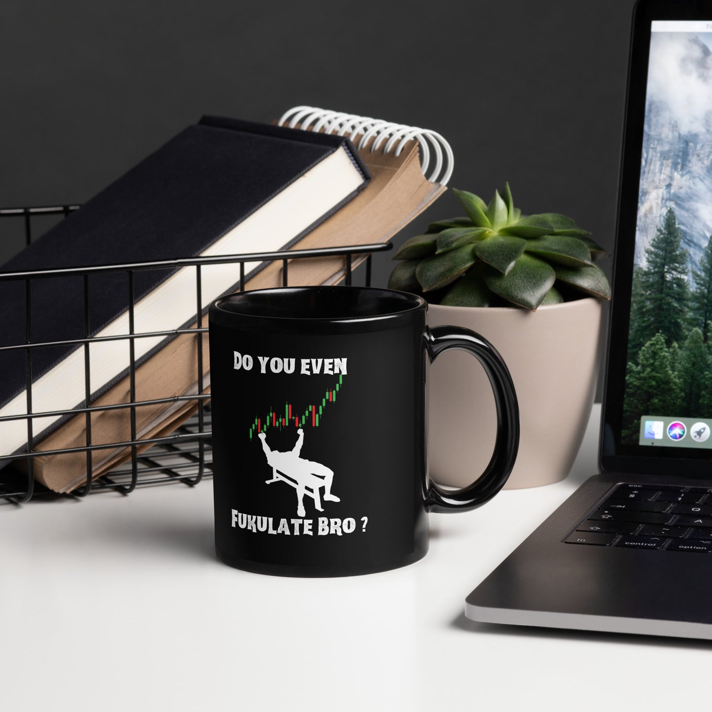 Lifestyle shot of black candlestick-lifter mug amid books, succulent plant, and scenic laptop screen