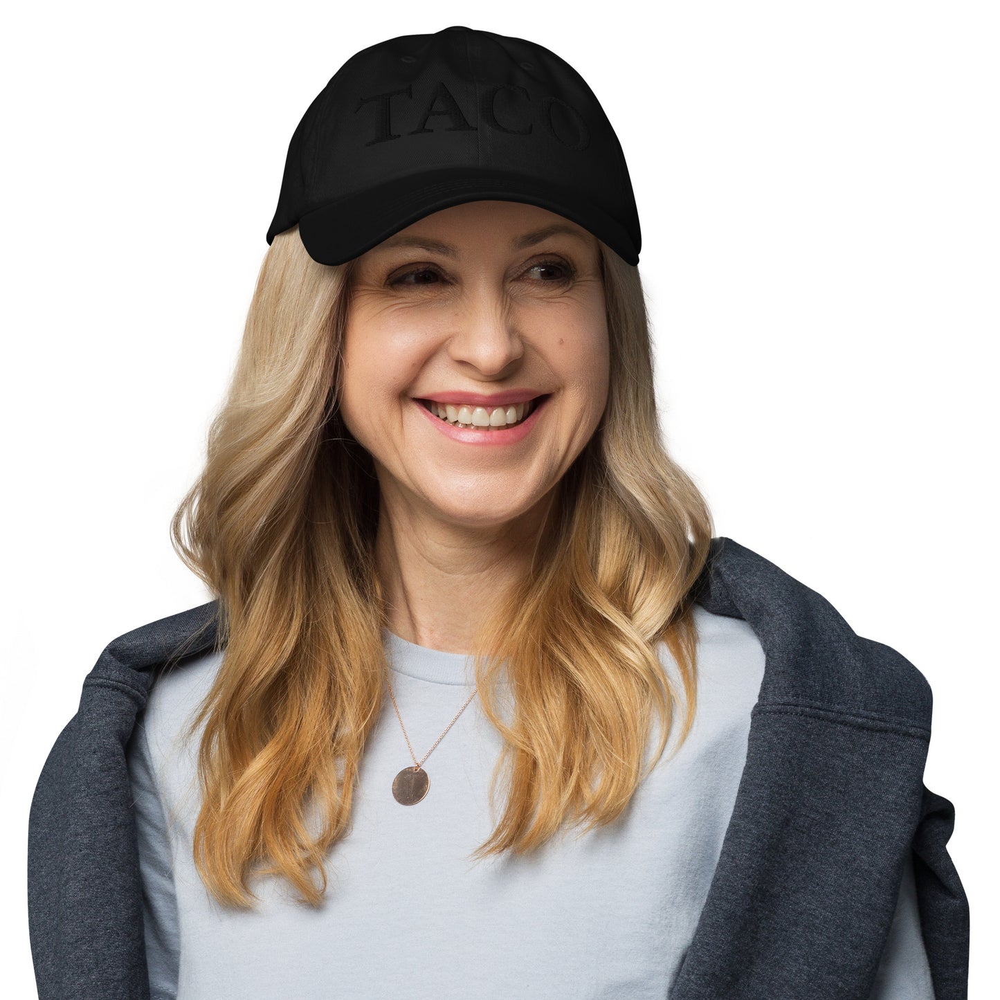 Front view of black dad hat with bold "DARK TACO" embroidery on smiling blonde model in gray tee