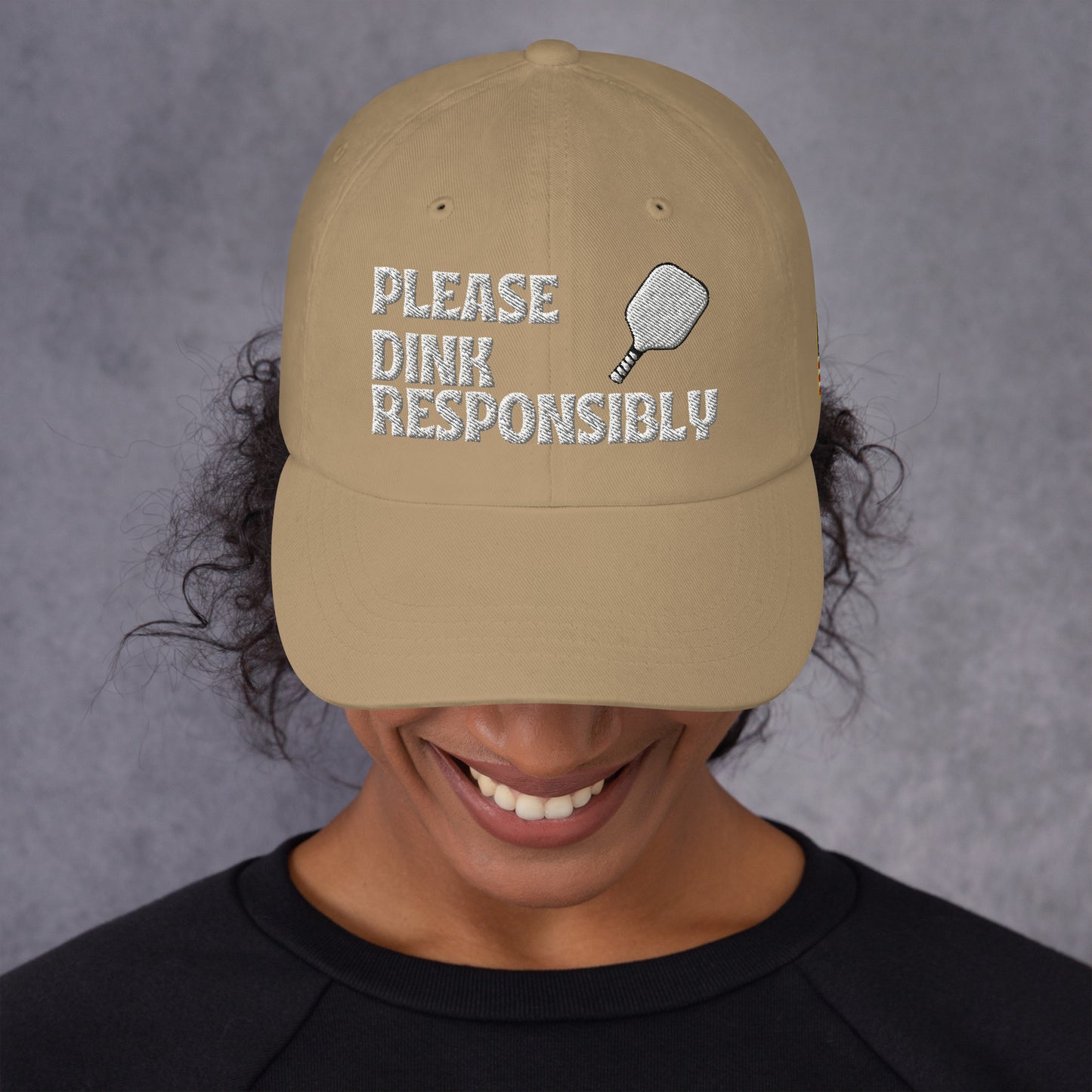 Side view of khaki dad hat on model with "PLEASE DINK RESPONSIBLY", paddle icon, and US flag patch