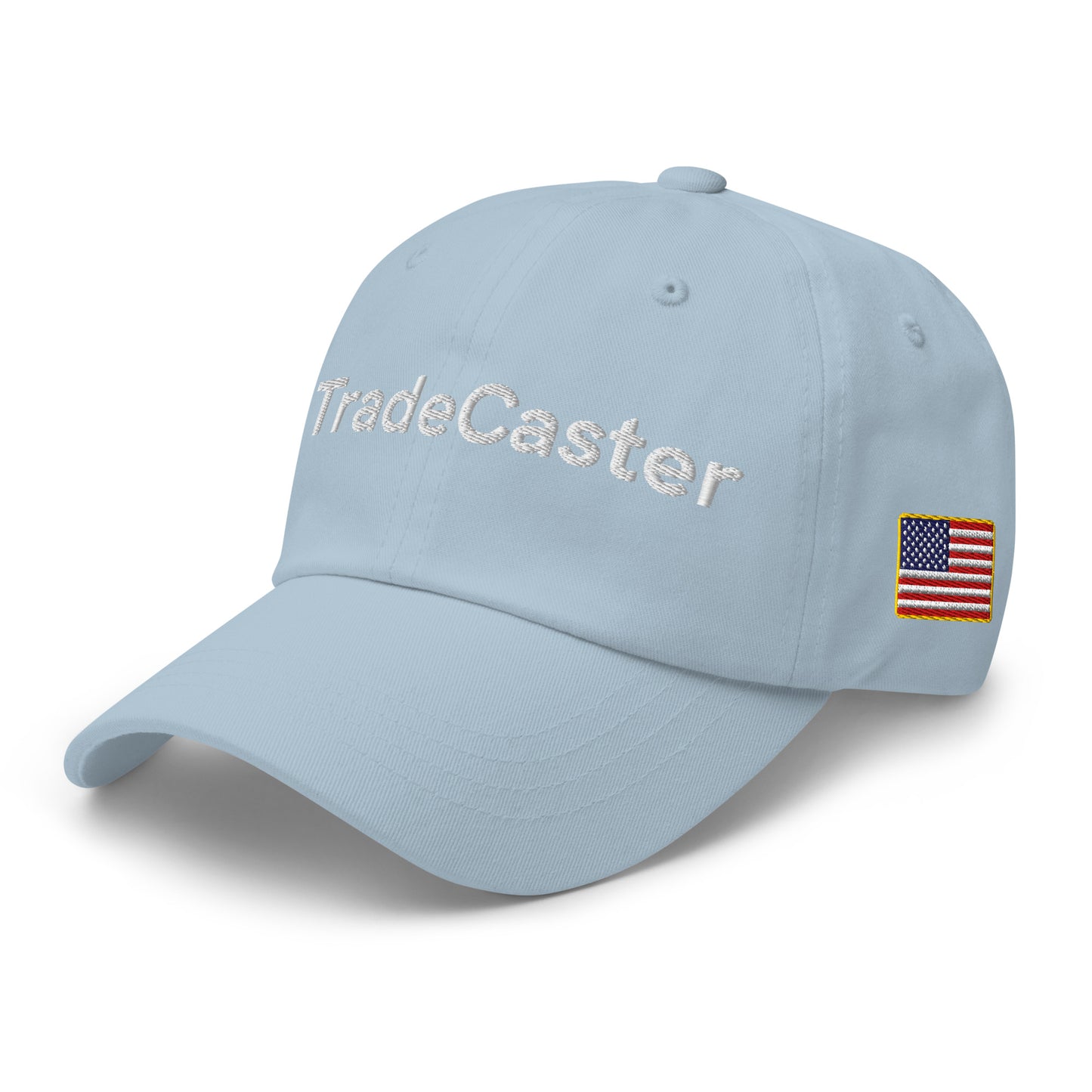 Front-right view of light blue dad hat featuring full white "TradeCaster" embroidery and US flag patch