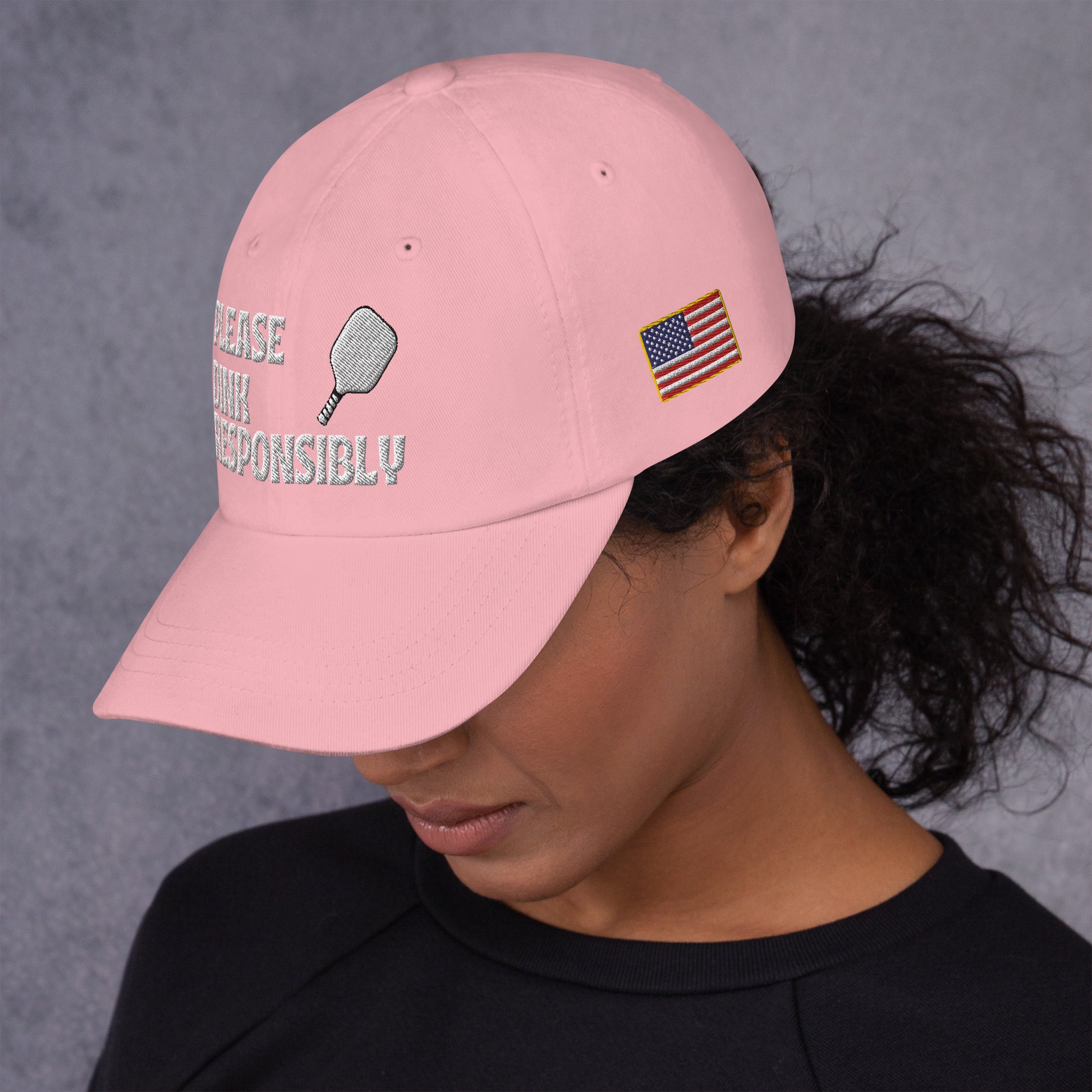 Side angle of pink dad hat on model, "PLEASE DINK RESPONSIBLY" embroidery with pickleball paddle and US flag patch