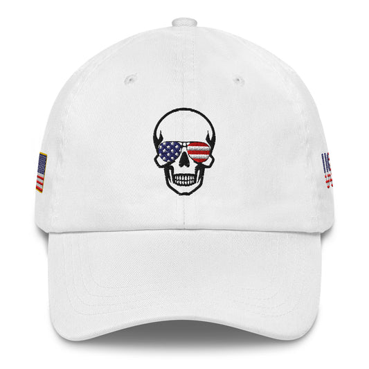 Front view of white dad hat with black skull in American flag sunglasses, flanked by USA flag patches