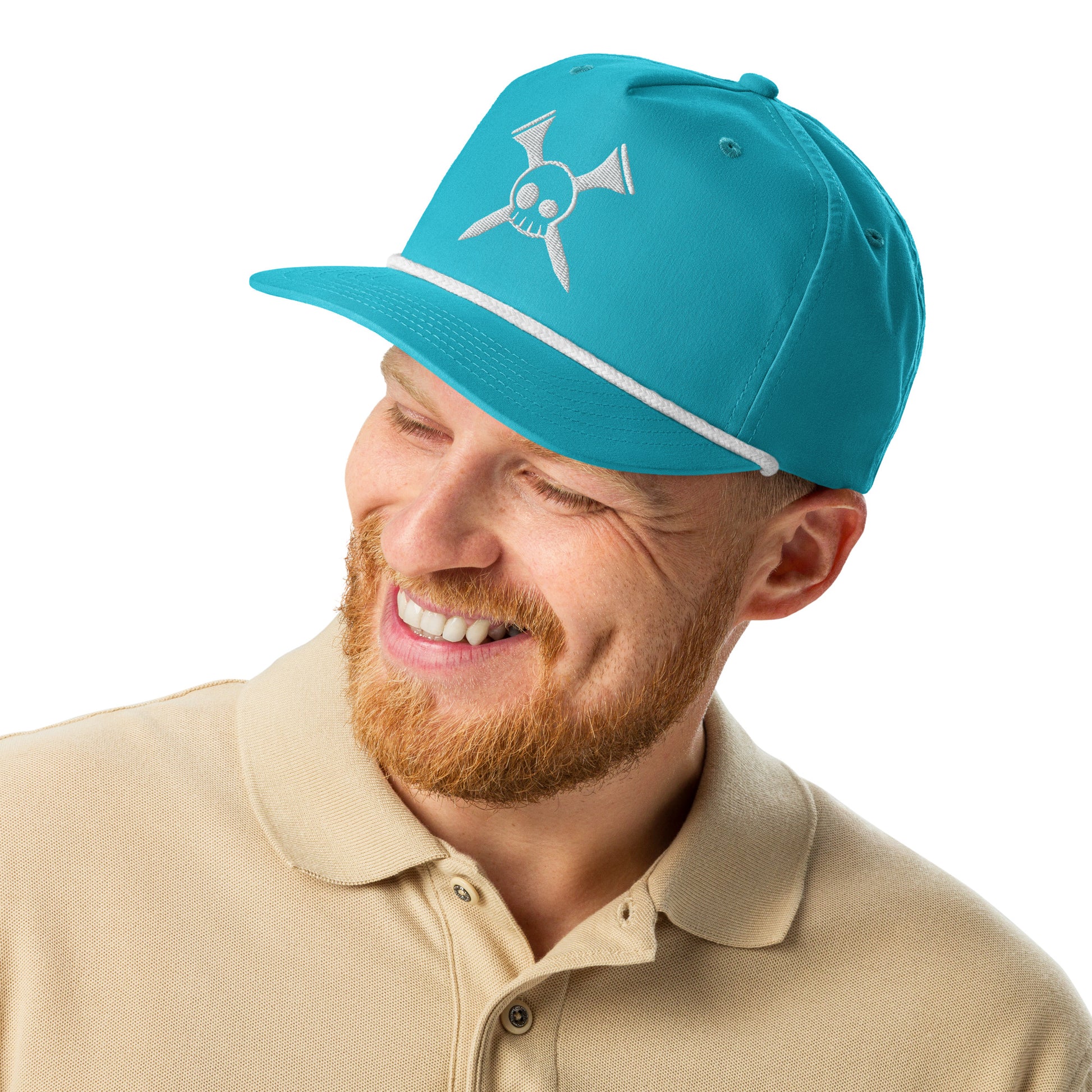 Smiling bearded model in front view of turquoise golf rope cap with white crossed-clubs skull embroidery