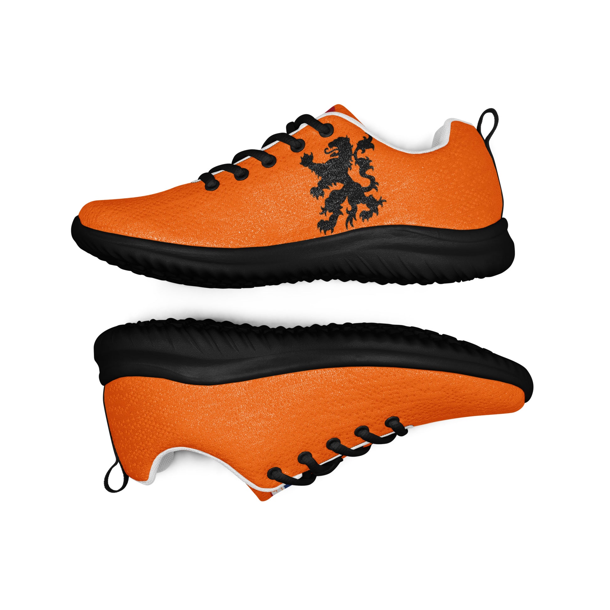 Orange athletic shoes pair mid-air, black Dutch lion and flag stripes visible, white laces top, darker soles below