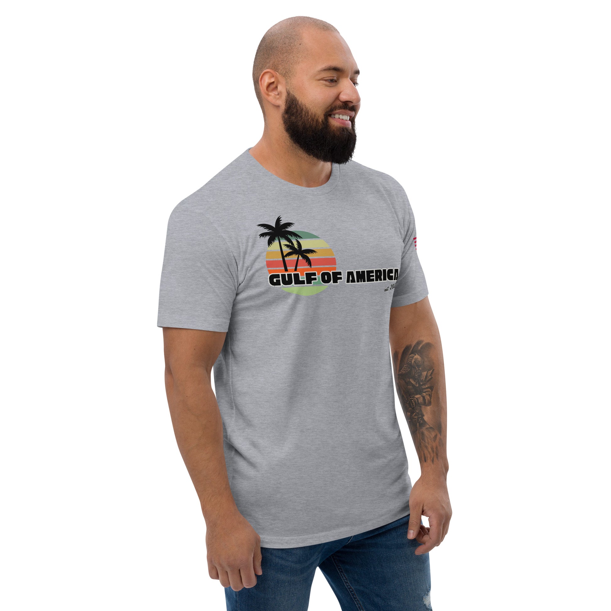 Left side view of grinning model in heather gray fitted tee, hint of sunset palm design