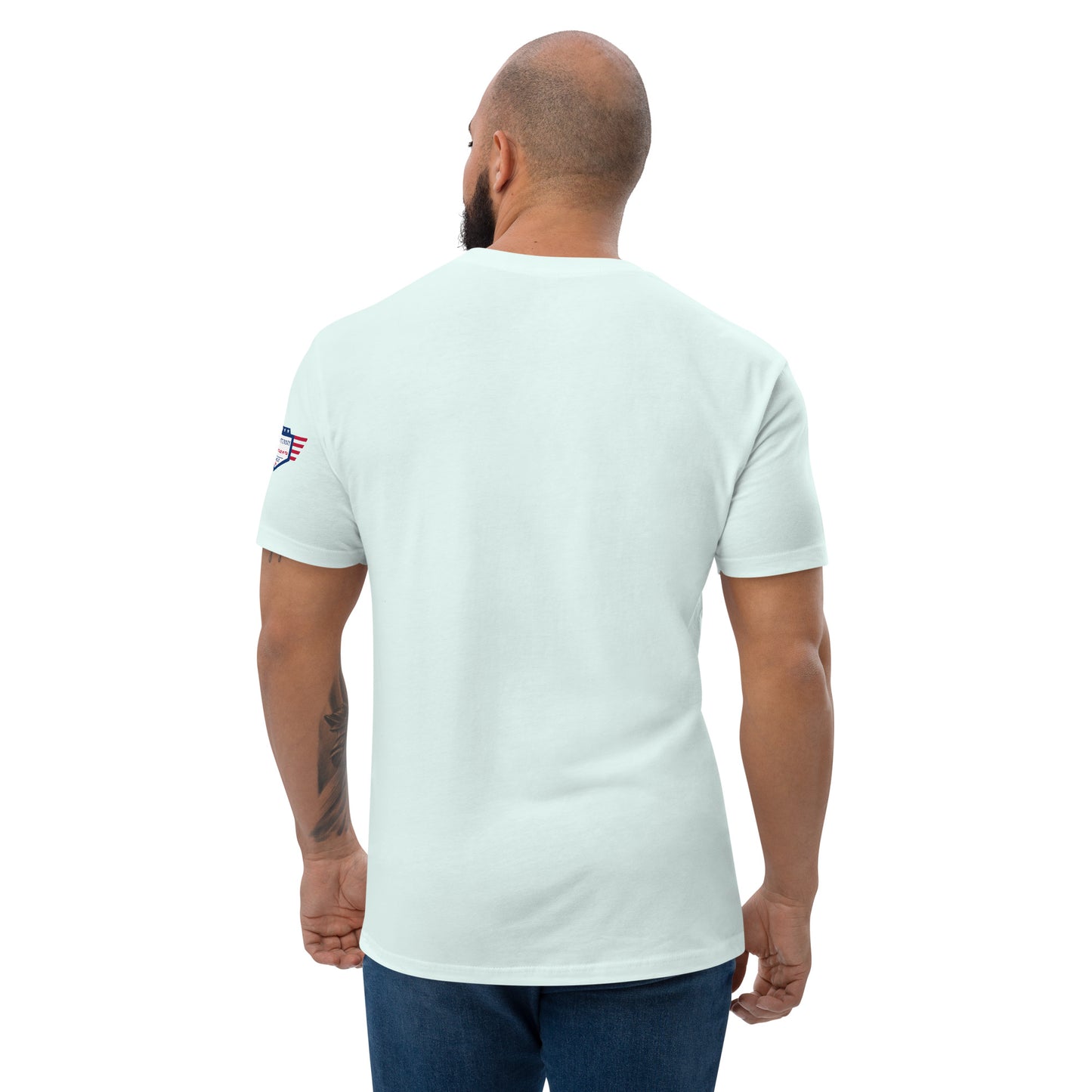 Back view of light blue fitted shirt on model, plain with small USA flag patch on sleeve—subtle patriotism from behind