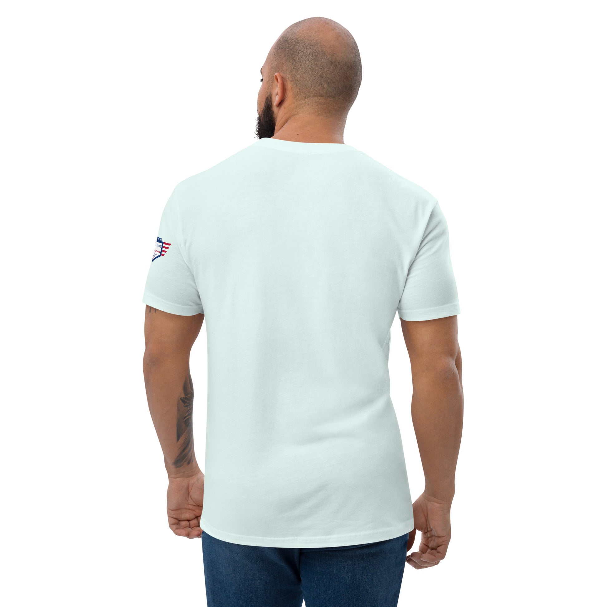 Back view of light blue fitted shirt on model, plain with small USA flag patch on sleeve—subtle patriotism from behind