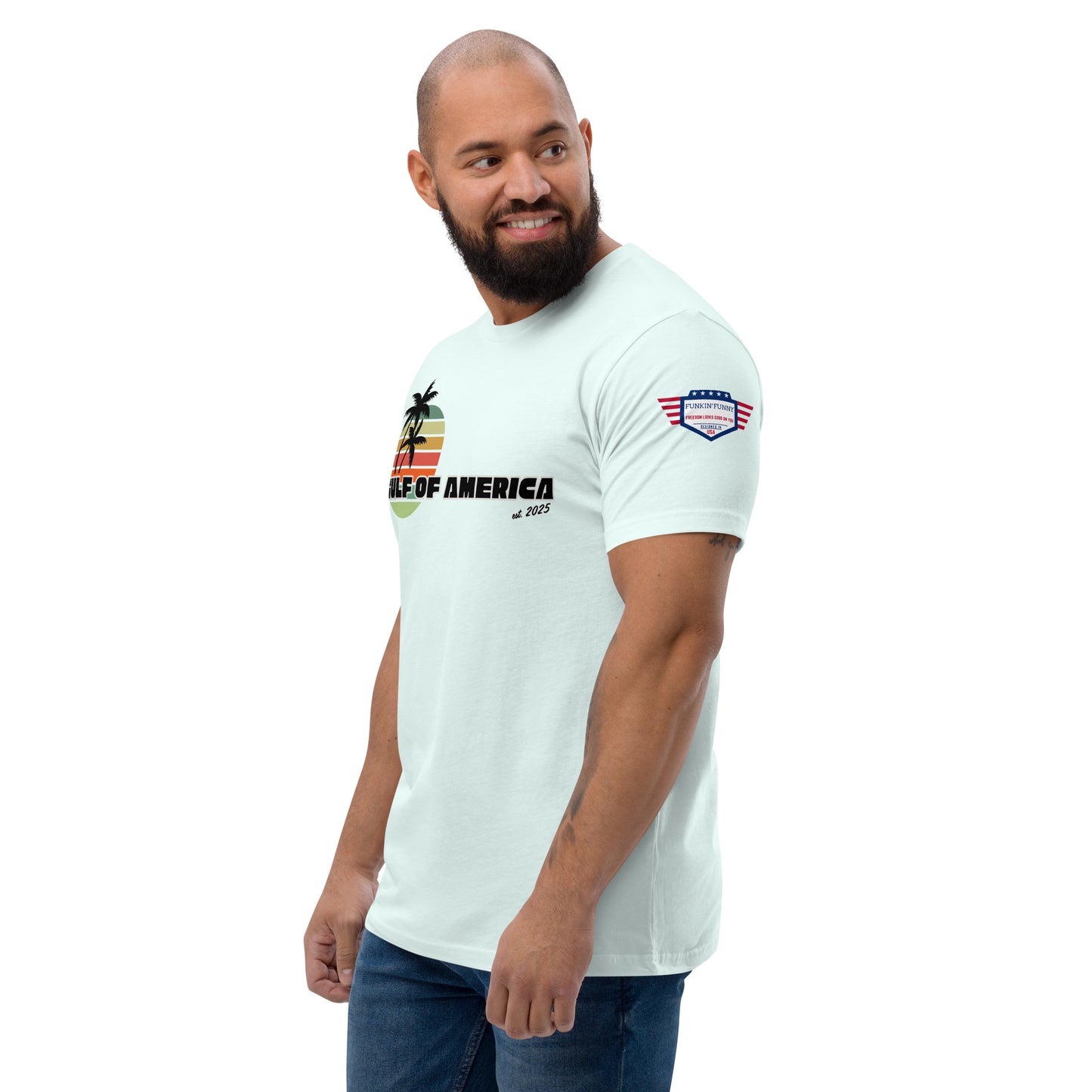 Side profile of bearded model in light blue "Gulf of America" tee, showing partial palm sunset design and flag patch on upper arm