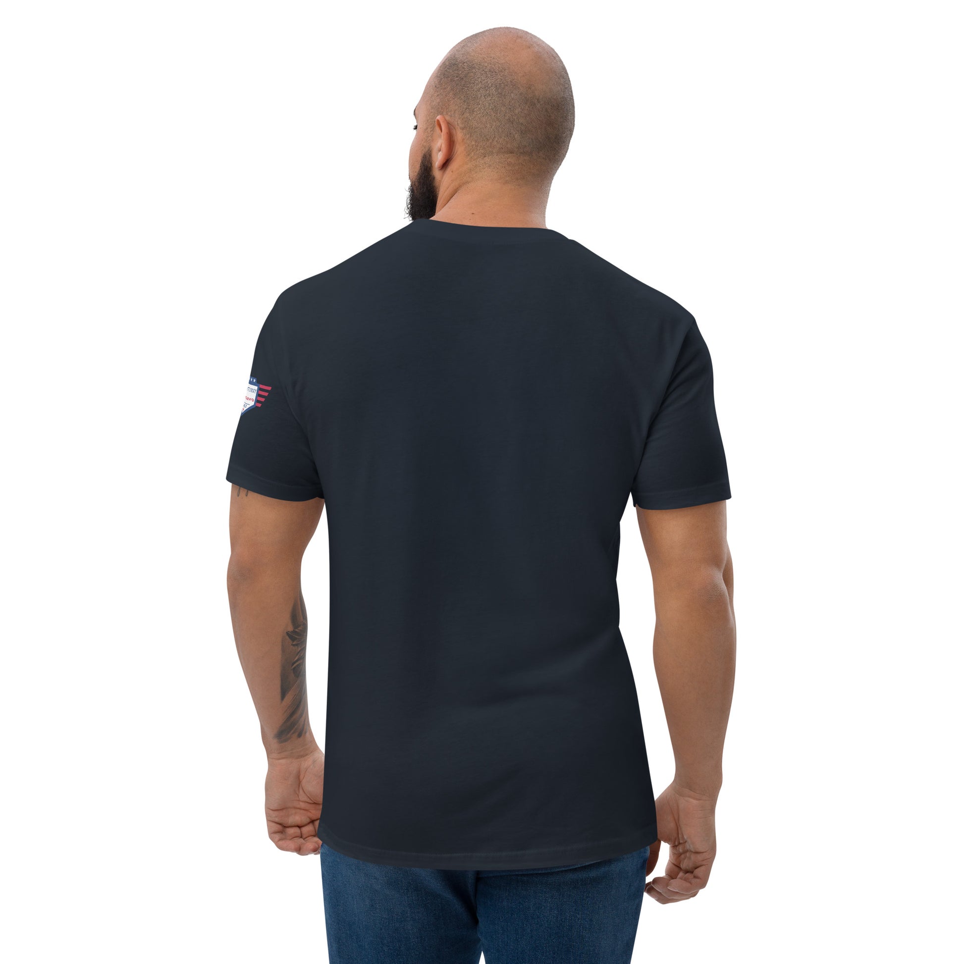 Back view of bearded model in plain midnight navy fitted shirt, small flag on sleeve