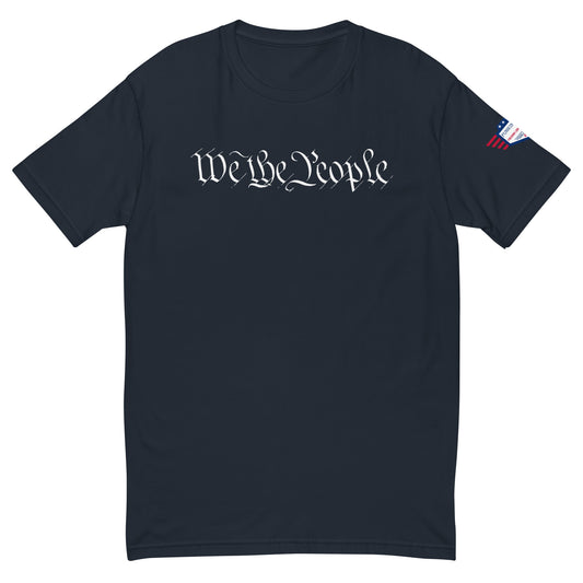 Flat front view of midnight navy fitted tee with white cursive "We the People" across chest and small US flag sleeve patch