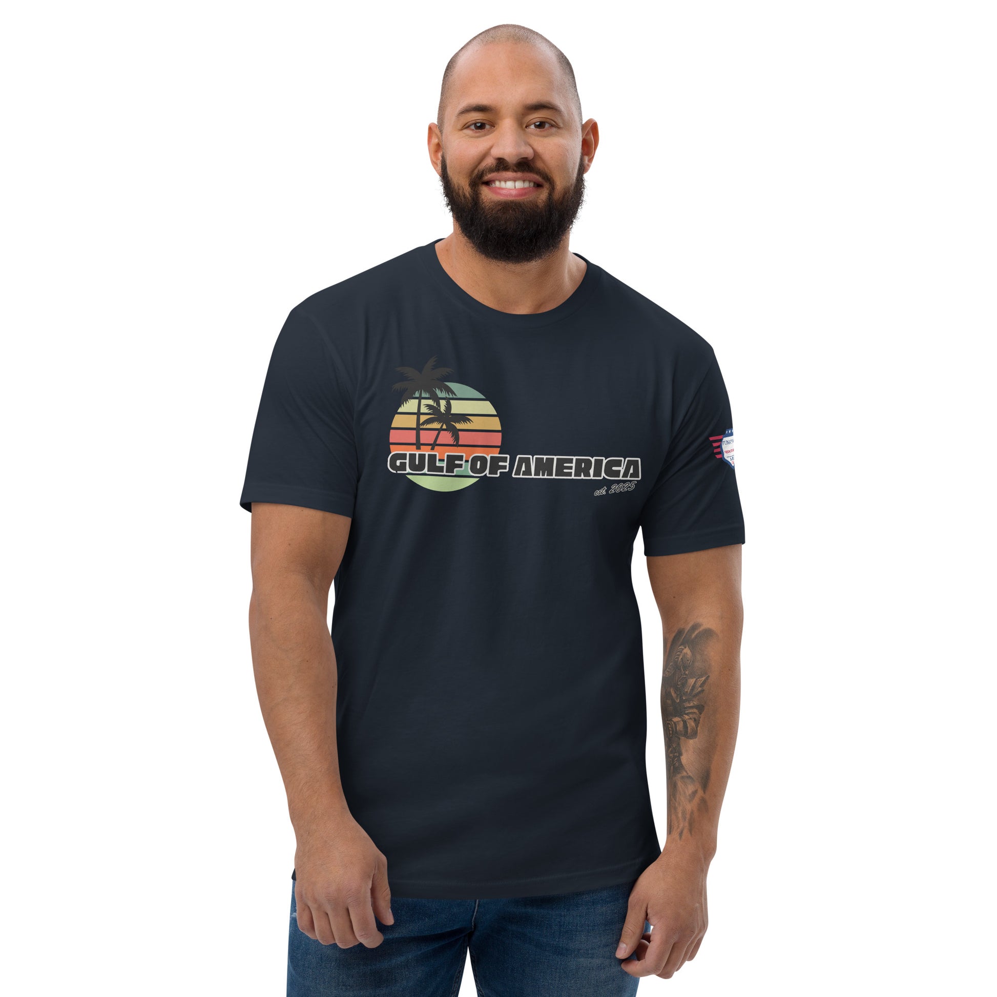 Front view of smiling bearded model in midnight navy Gulf of America fitted tee, vibrant palm sunset print