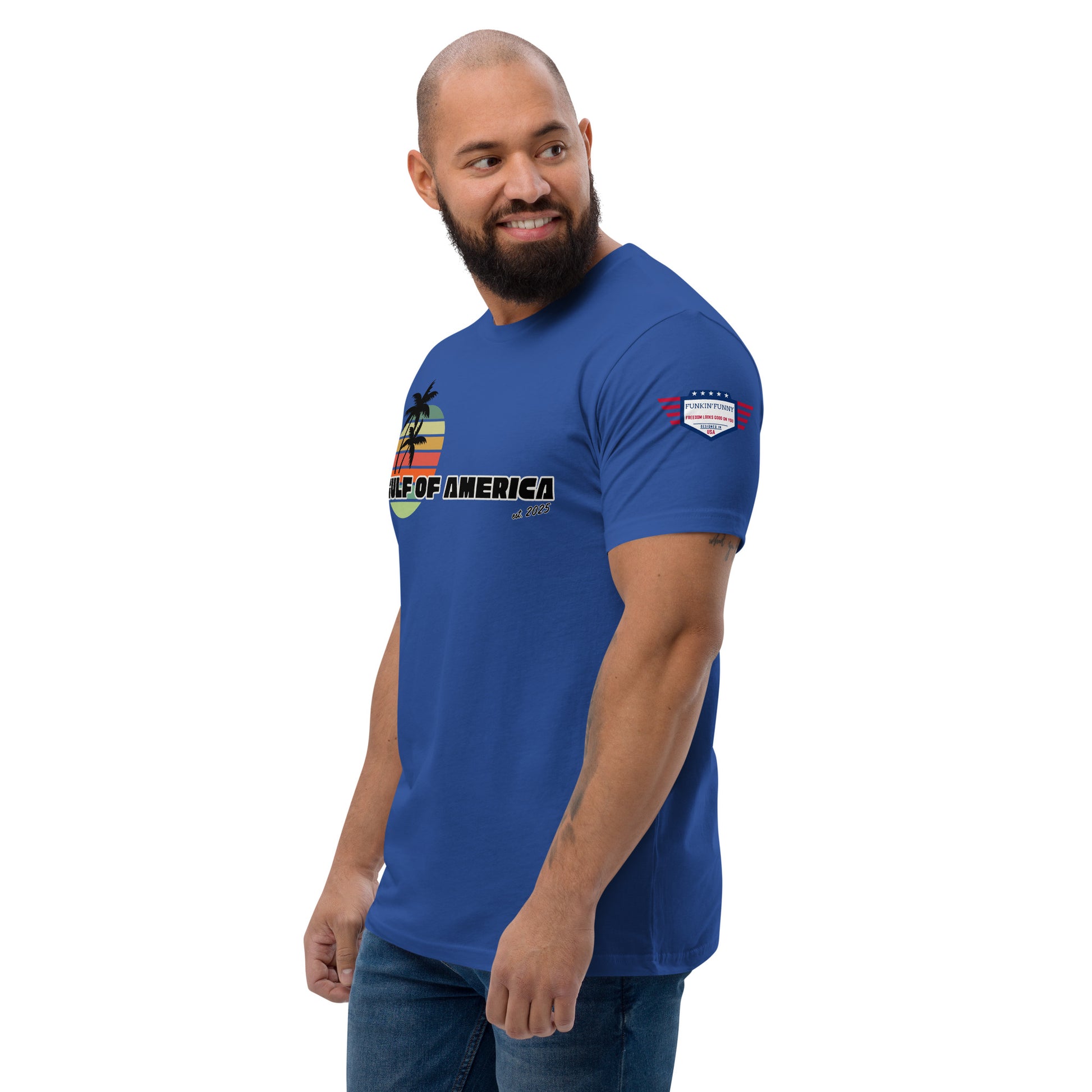 Bearded model side profile in royal blue Gulf of America tee, showing partial palm sunset design and sleeve flag