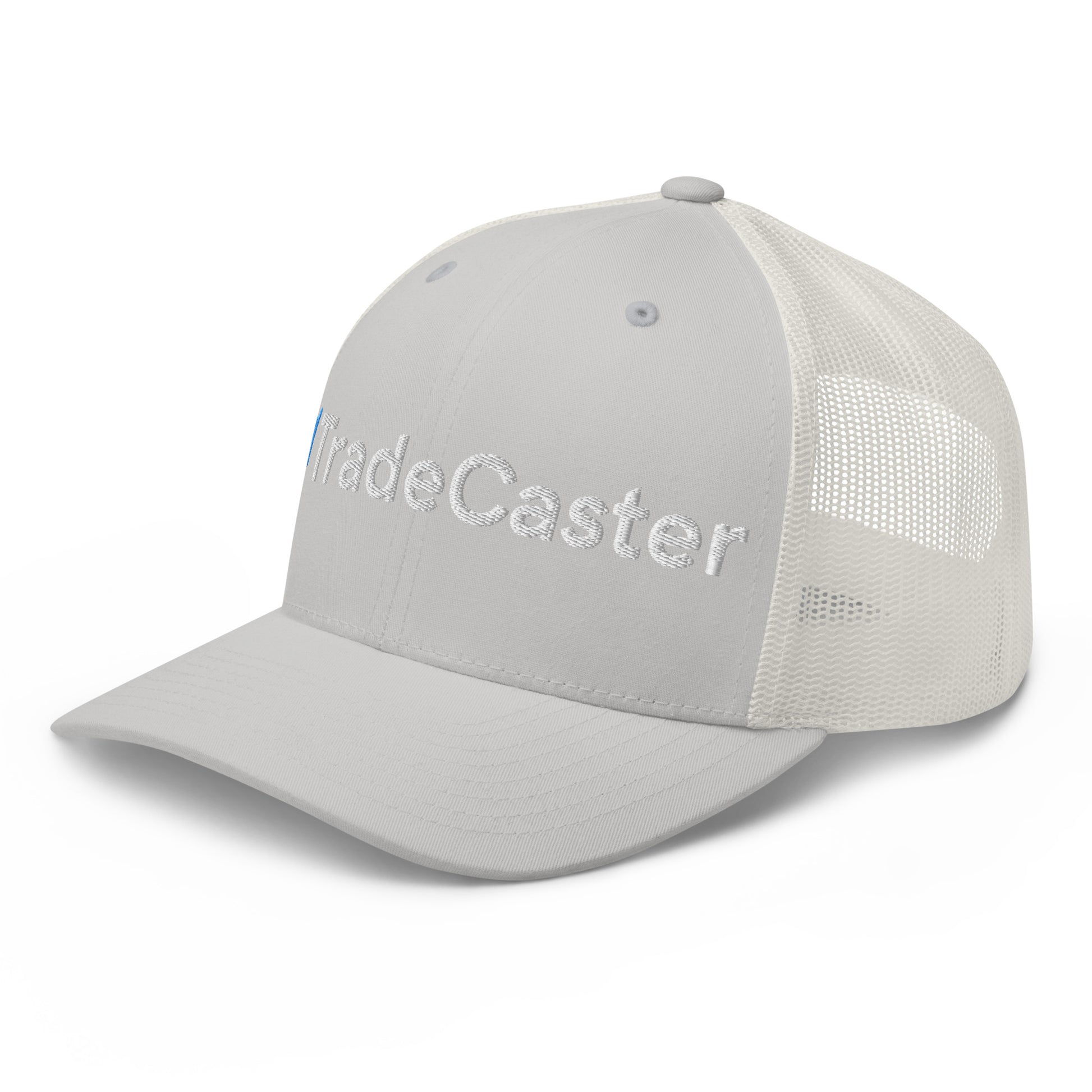 Left side view of gray trucker cap highlighting "Trade" 3D puff embroidery, transitioning to white mesh