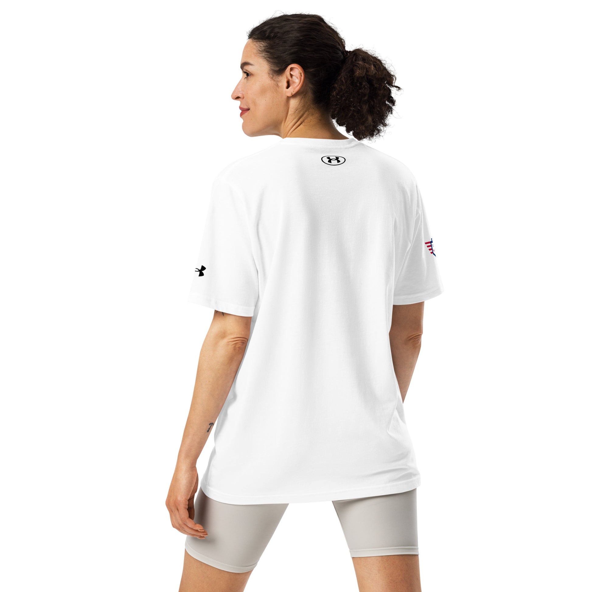Back view of plain white Under Armour athletic tee on woman, small logo between shoulders, grey shorts