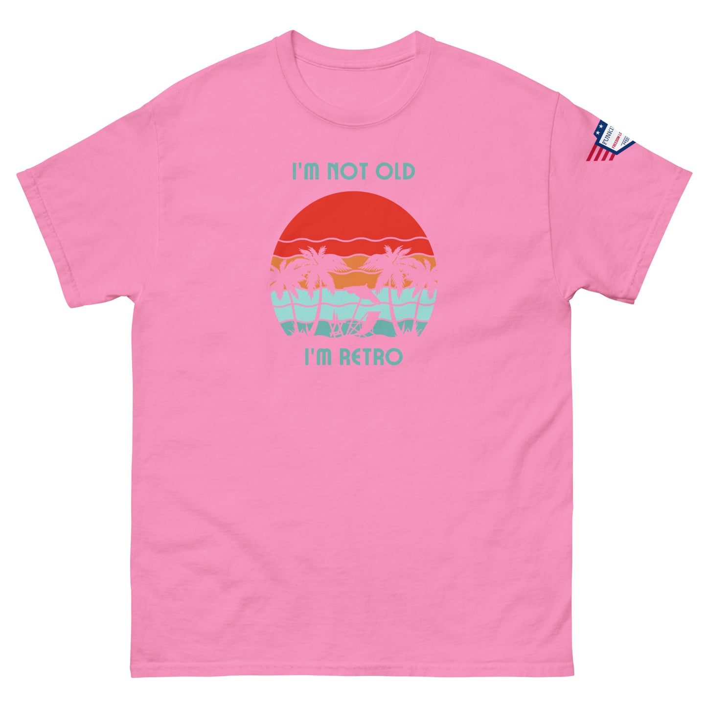 Front view of pink unisex t-shirt featuring "I'm not old I'm retro" print over retro beach sunset with palms, flag on sleeve