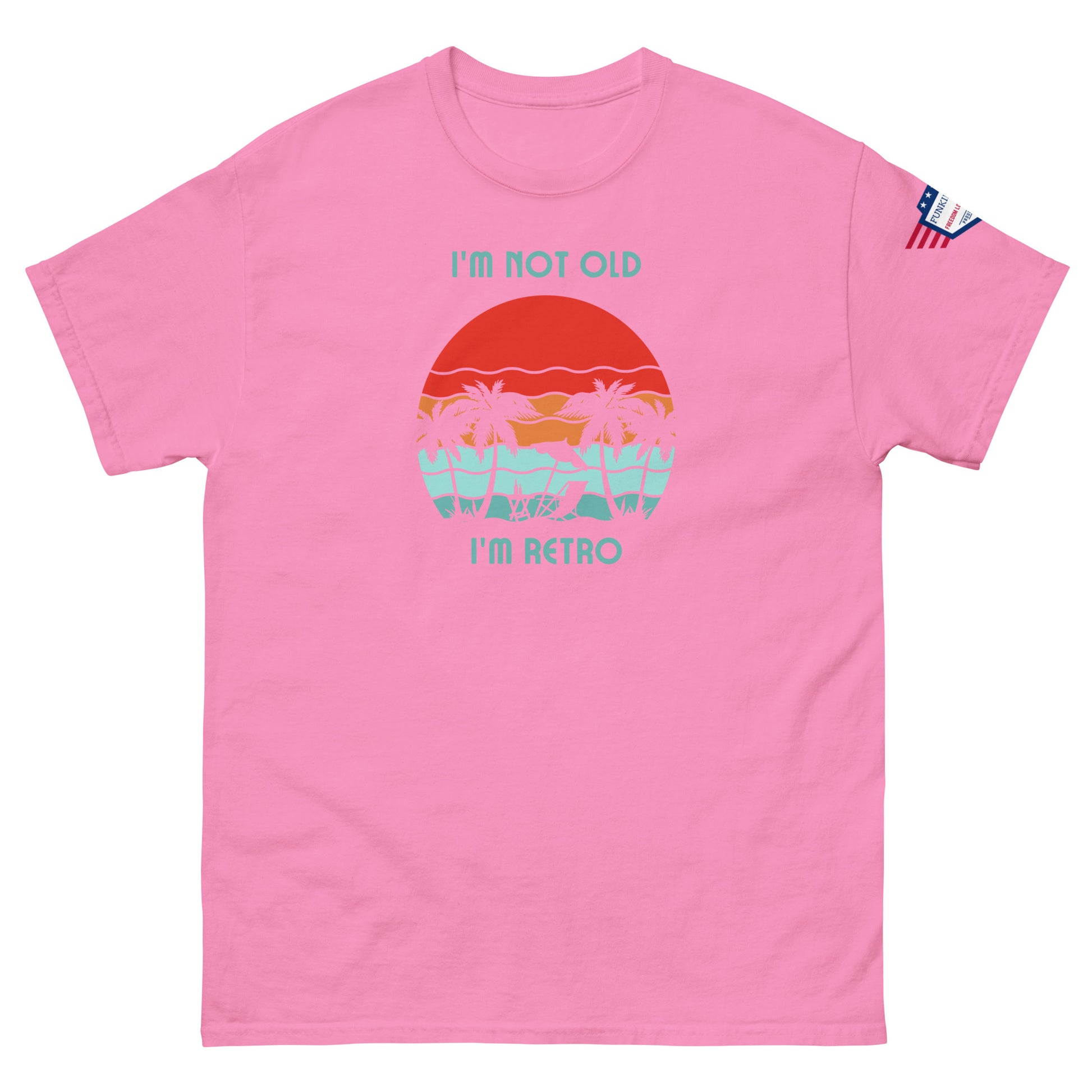 Front view of pink unisex t-shirt featuring "I'm not old I'm retro" print over retro beach sunset with palms, flag on sleeve