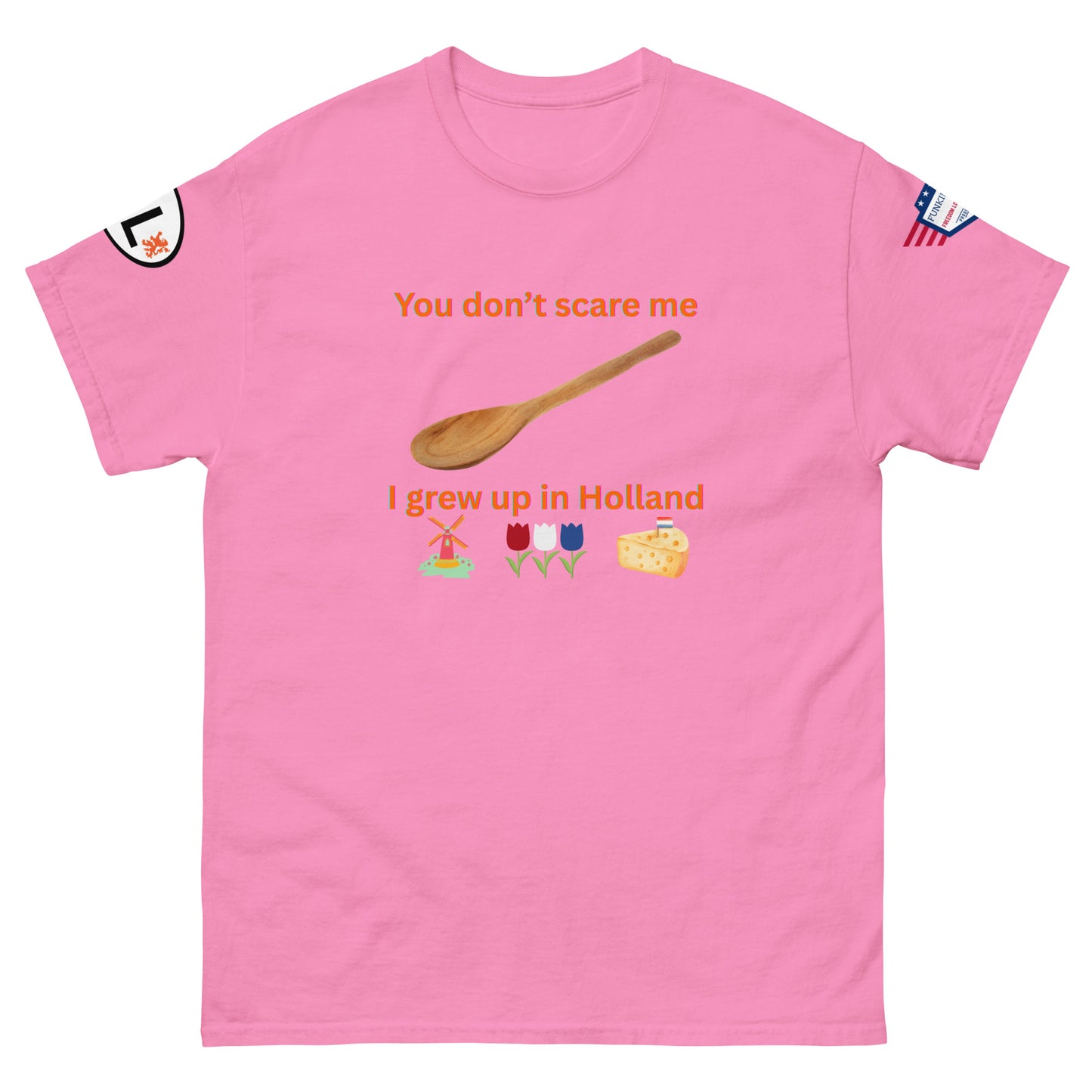 Front view of hot pink unisex tee with orange "You don't scare me, I grew up in Holland" print, wooden spoon, windmill/tulip/cheese emojis, sleeve patches