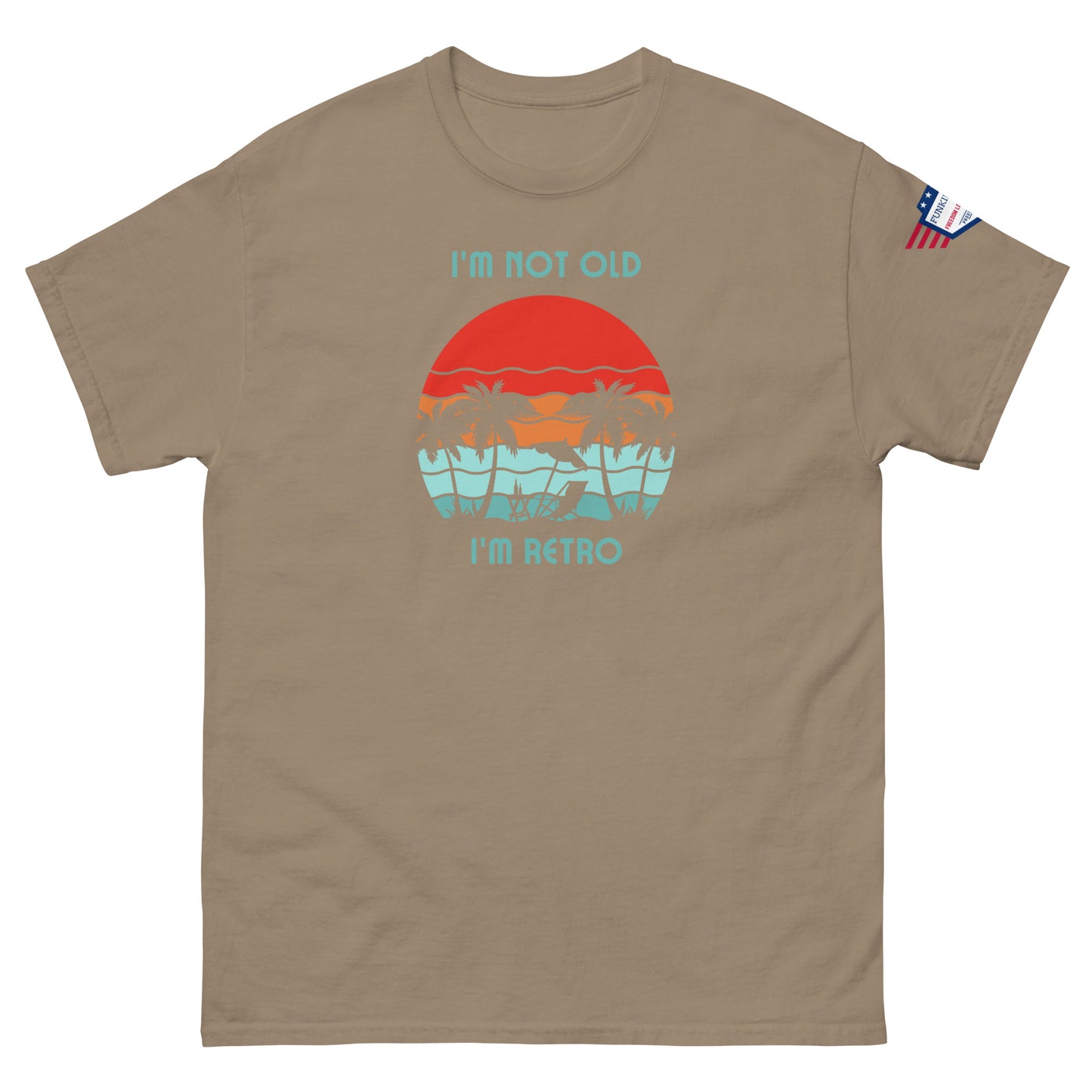 Front view of tan unisex t-shirt showing "I'm not old I'm retro" over orange sun, teal palms graphic, flag sleeve detail