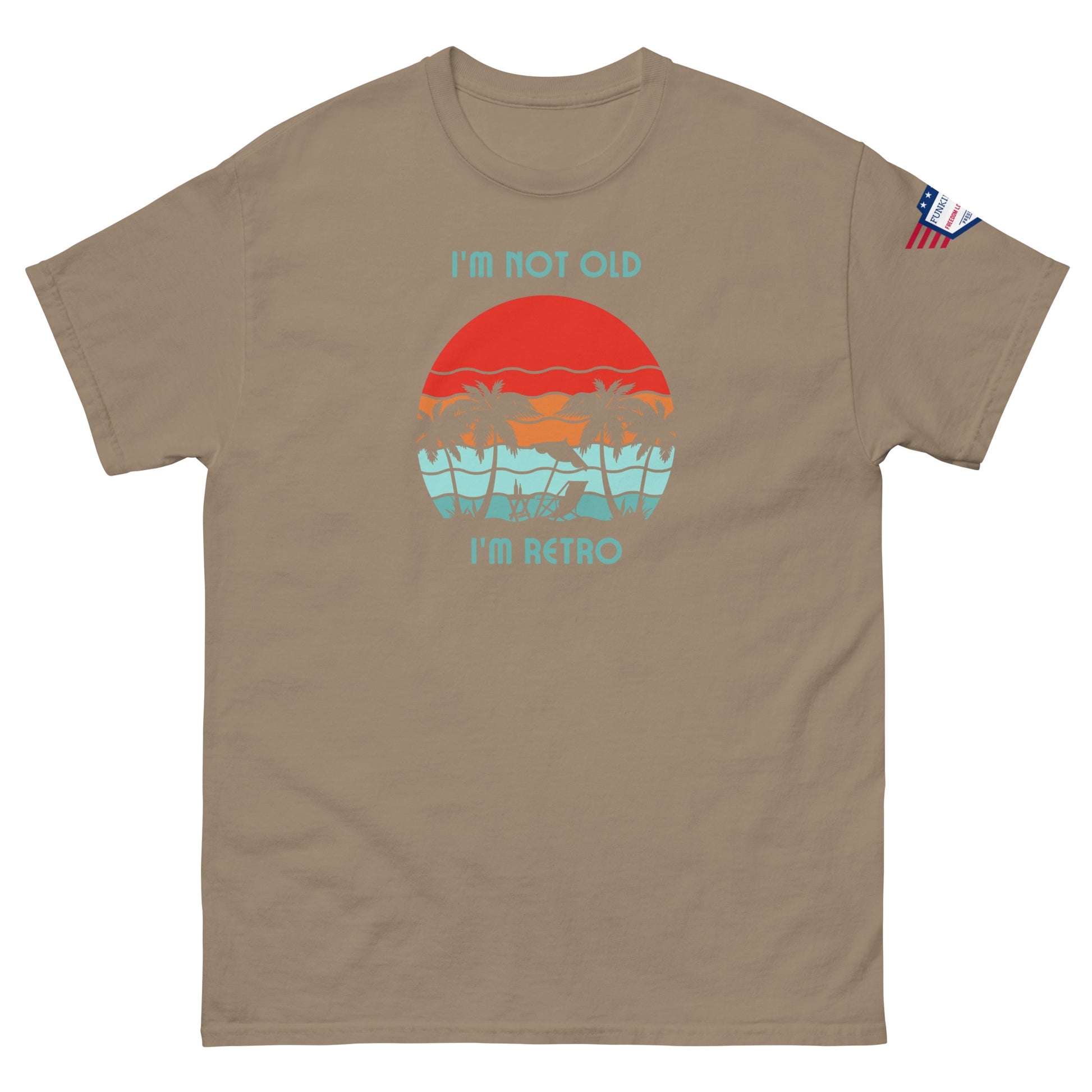Front view of tan unisex t-shirt showing "I'm not old I'm retro" over orange sun, teal palms graphic, flag sleeve detail