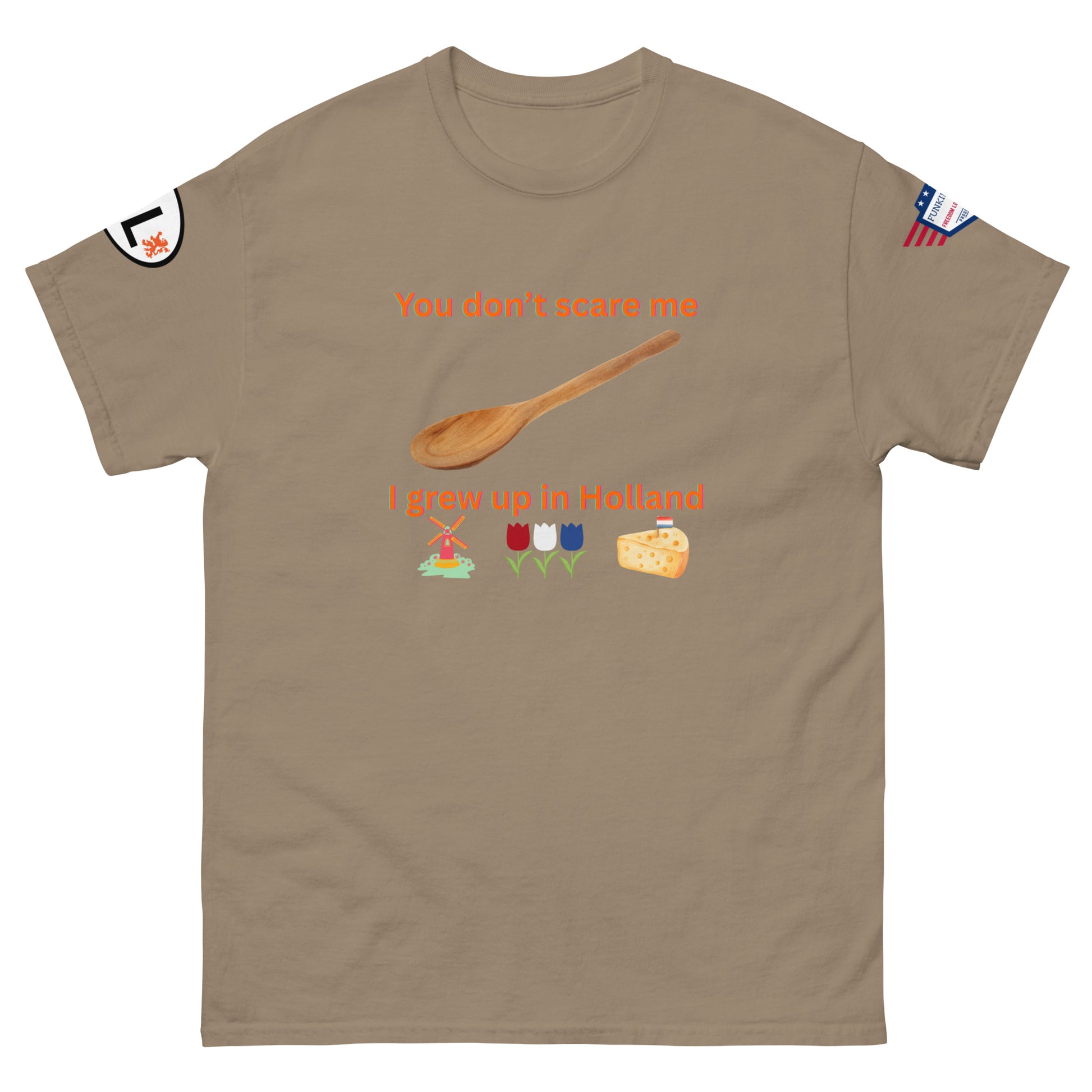 Front view of khaki unisex tee with orange "You don't scare me, I grew up in Holland" print, wooden spoon, windmill/tulip/cheese emojis, sleeve patches