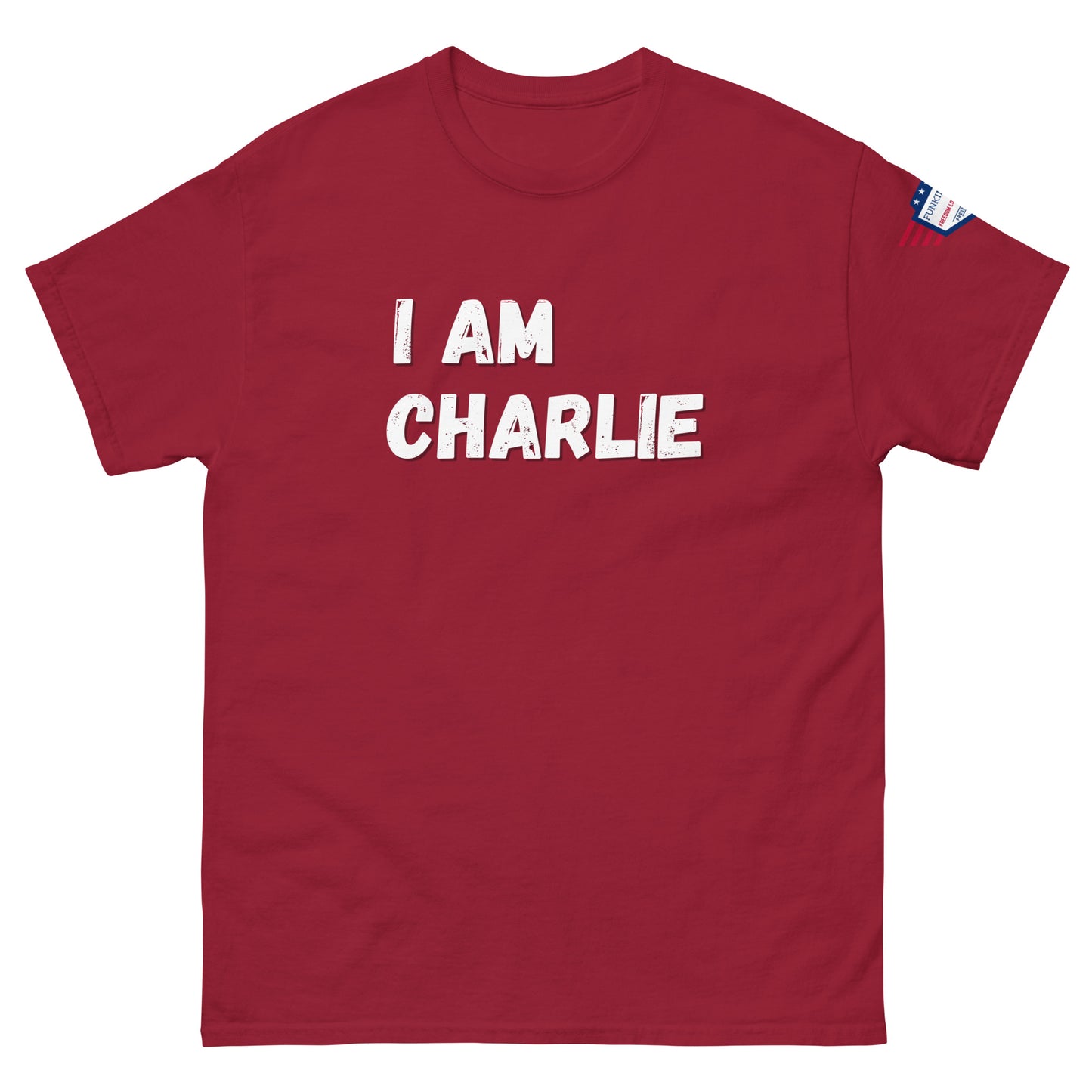 Front view of red unisex tee with bold white "I AM CHARLIE" graphic and small USA flag sleeve patch