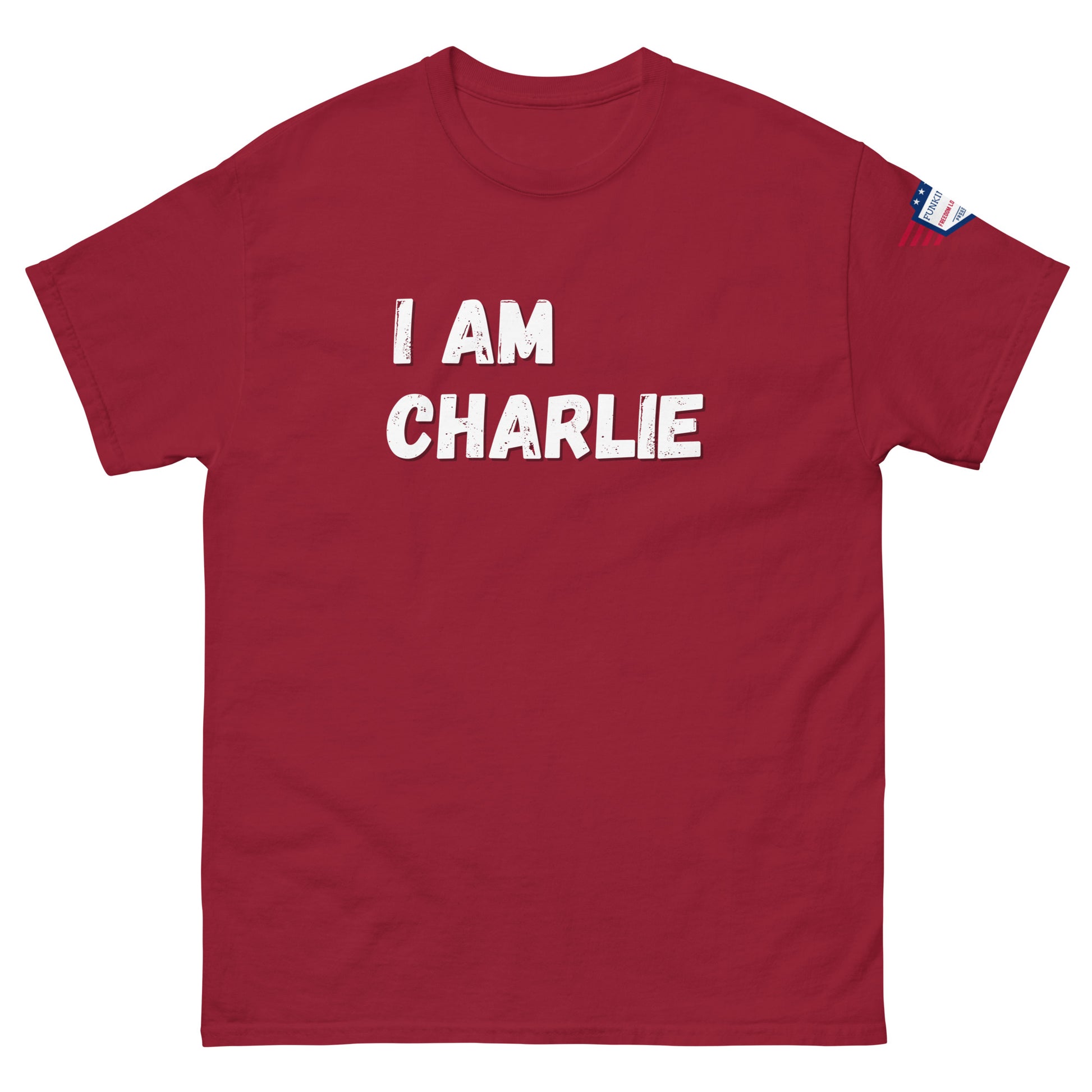 Front view of red unisex tee with bold white "I AM CHARLIE" graphic and small USA flag sleeve patch