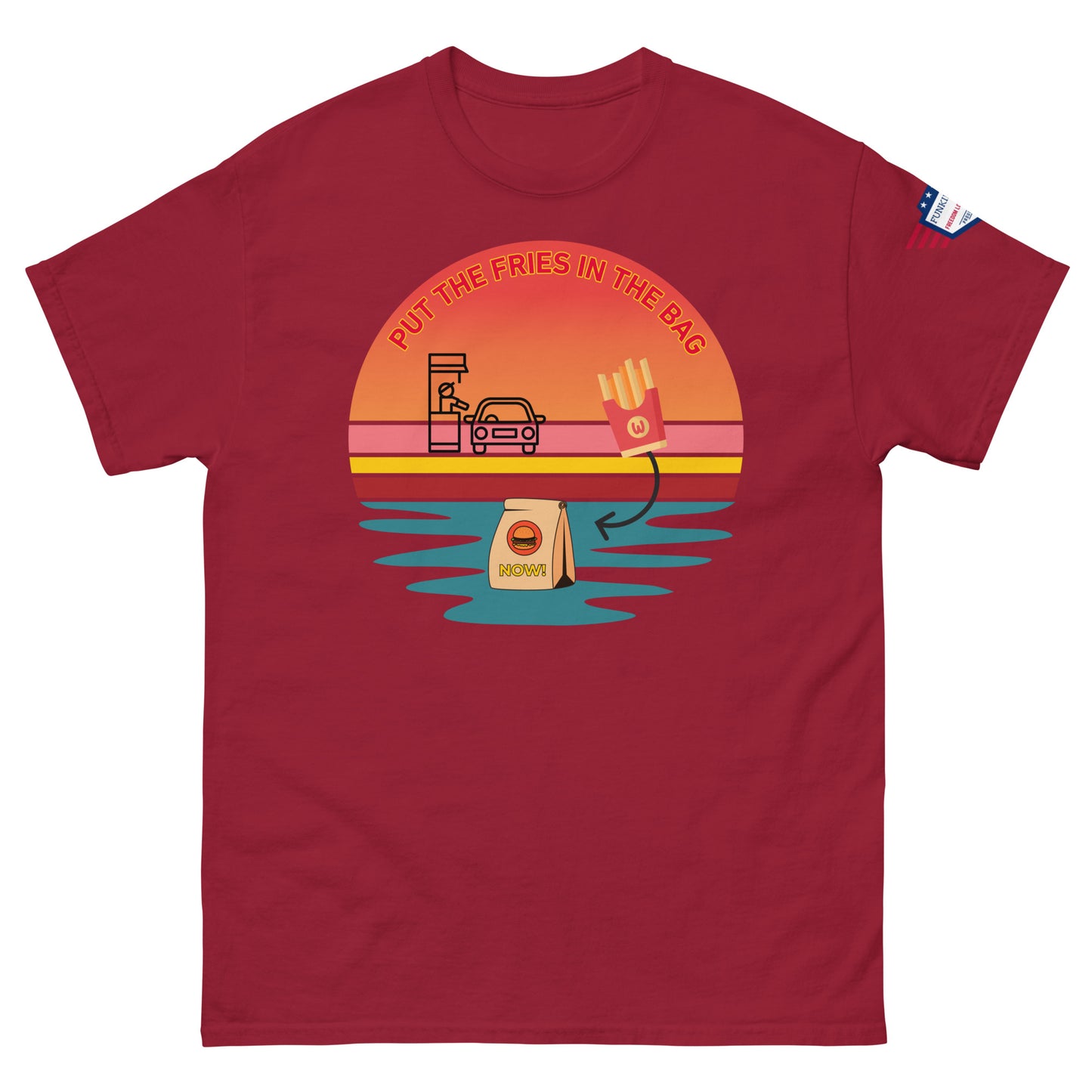 Front view of deep red unisex t-shirt with "PUT THE FRIES IN THE BAG" vibrant drive-thru sunset scene