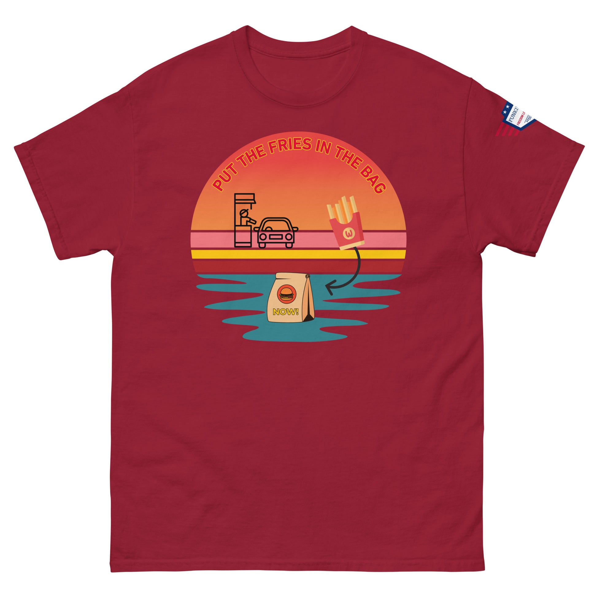 Front view of deep red unisex t-shirt with "PUT THE FRIES IN THE BAG" vibrant drive-thru sunset scene