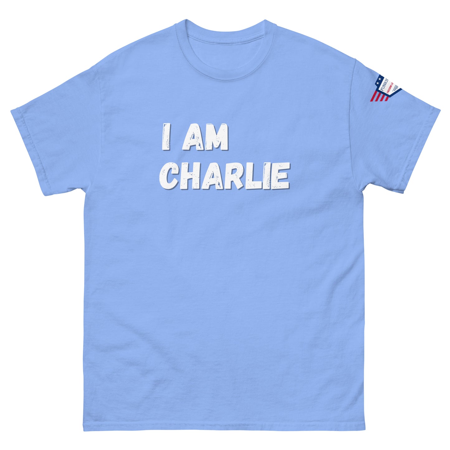 Front view of light blue unisex tee with bold white "I AM CHARLIE" print and small American flag sleeve patch