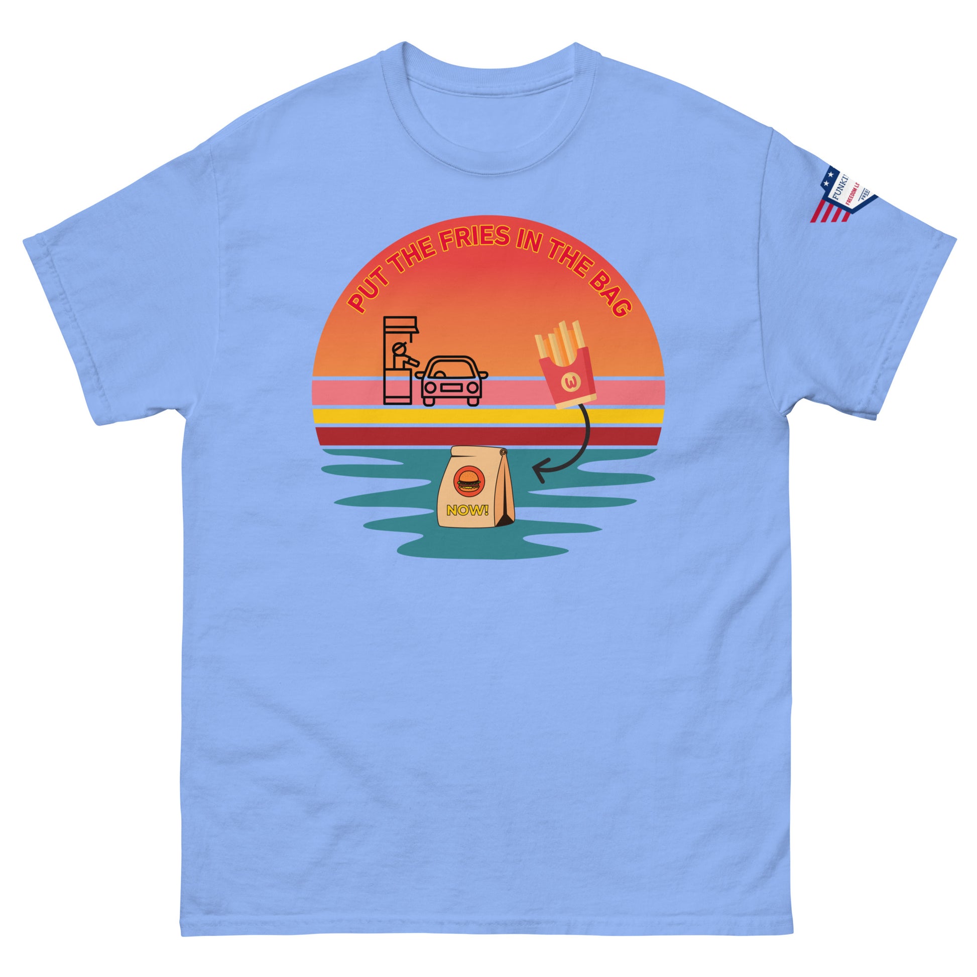 Front view of light blue unisex T-shirt displaying "Put the fries in the bag" retro drive-thru sunset print and flag patch