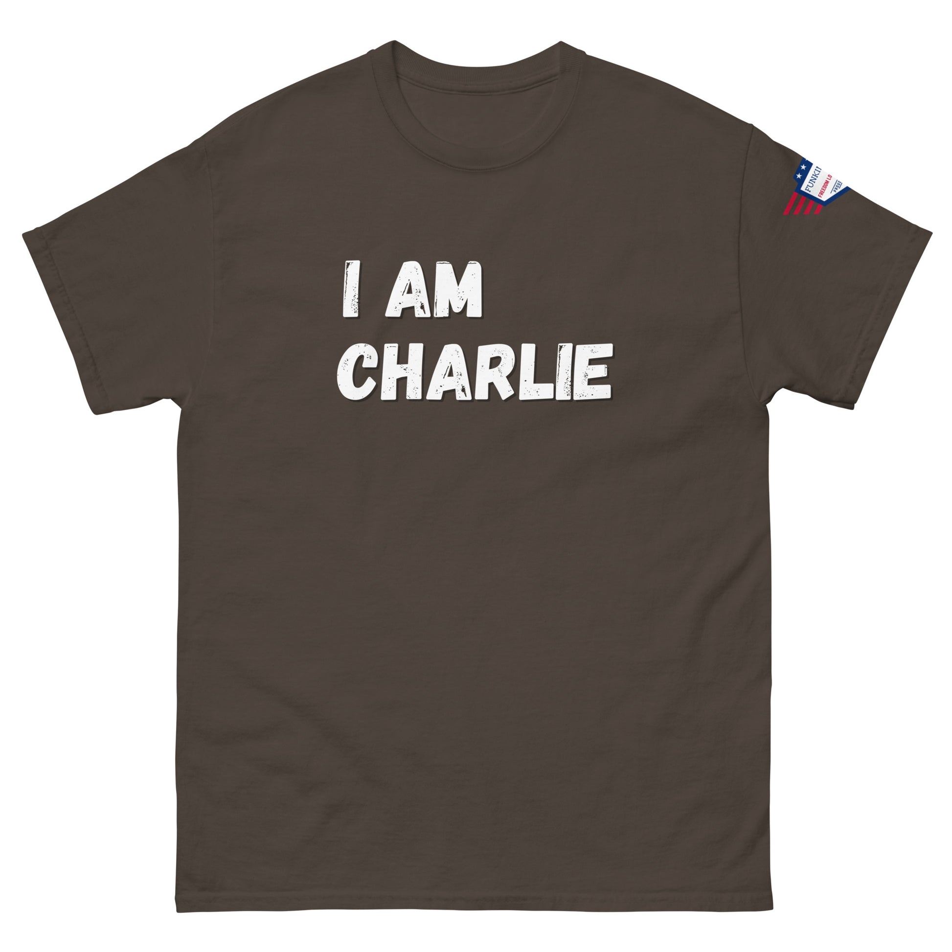 Front view of dark brown unisex tee with bold white "I AM CHARLIE" print and small American flag sleeve patch