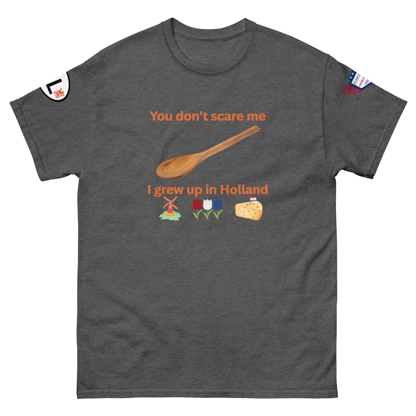 Front view of charcoal gray unisex tee with orange "You don't scare me, I grew up in Holland" print, wooden spoon, windmill/tulip/cheese emojis, sleeve patches