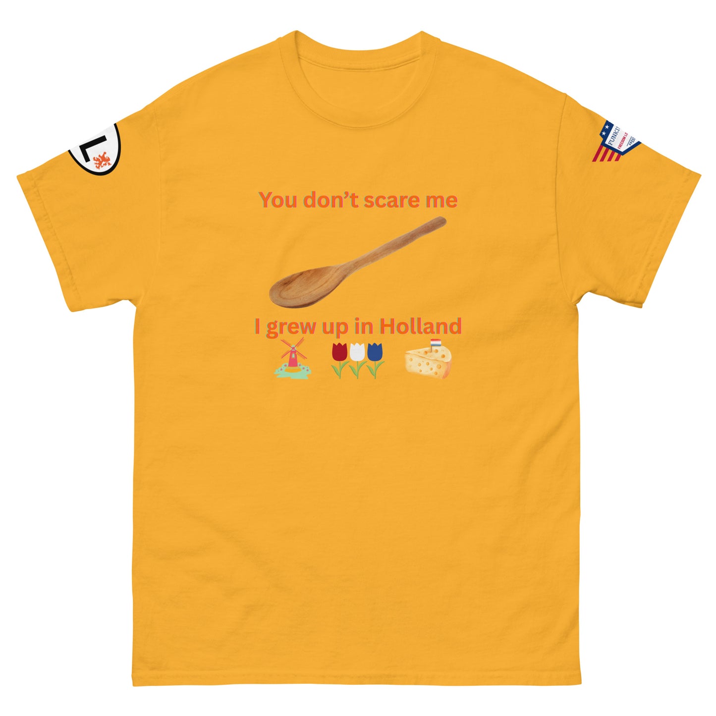 Front view of gold yellow unisex tee with orange "You don't scare me, I grew up in Holland" print, wooden spoon, windmill/tulip/cheese emojis, sleeve patches