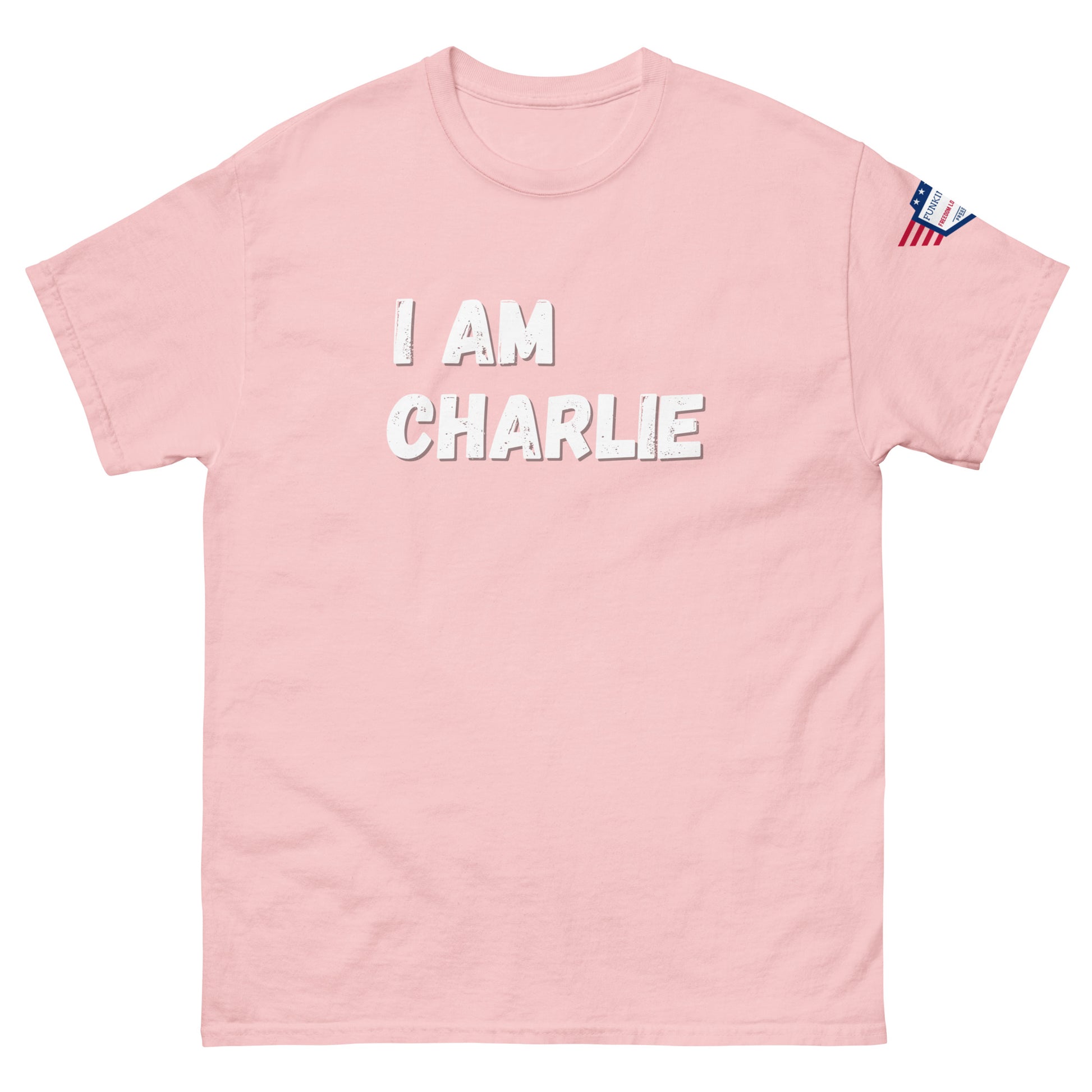 Baby pink unisex tee front, white "I AM CHARLIE" print pops, US flag on right sleeve