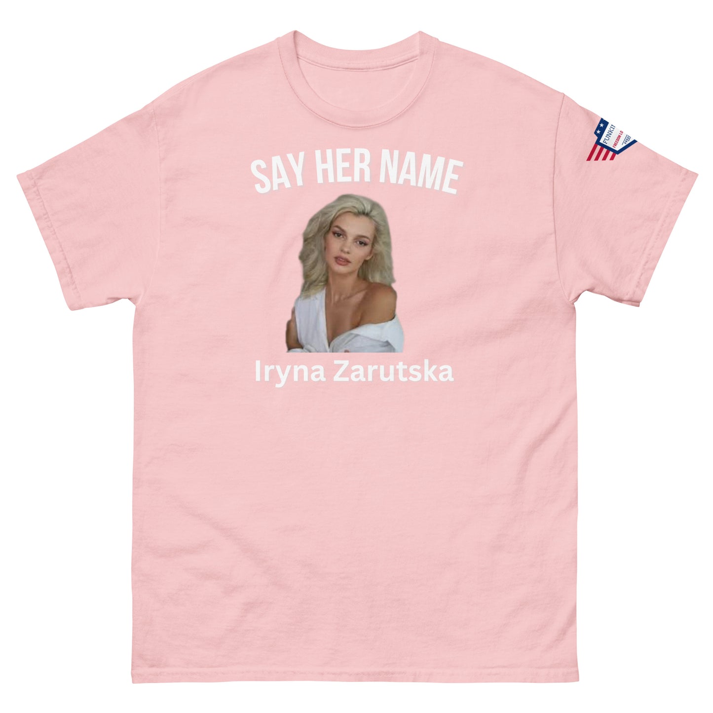 Front view of baby pink unisex tee featuring "SAY HER NAME", sultry Iryna Zarzutska portrait, her name in white print, flag patch