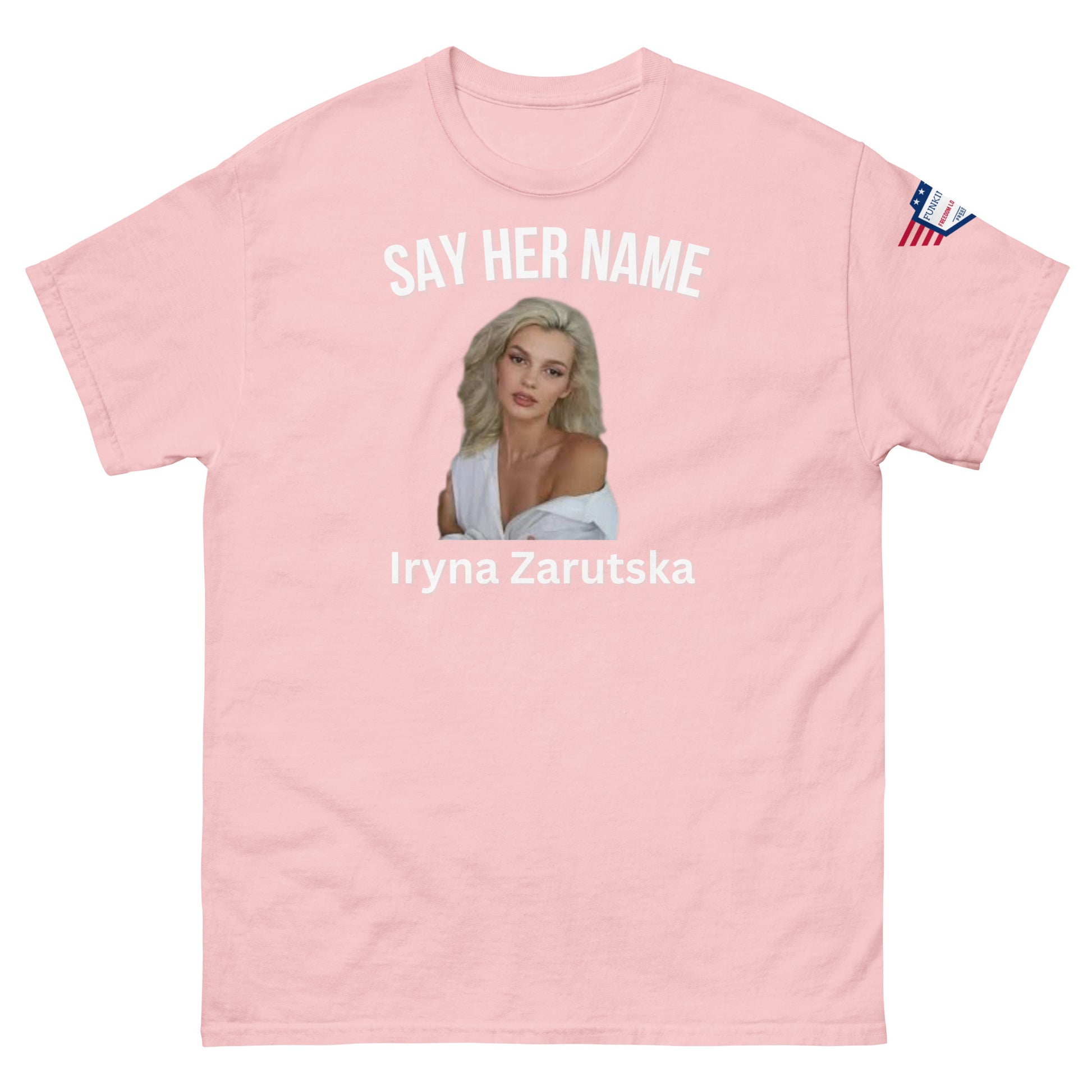 Front view of baby pink unisex tee featuring "SAY HER NAME", sultry Iryna Zarzutska portrait, her name in white print, flag patch