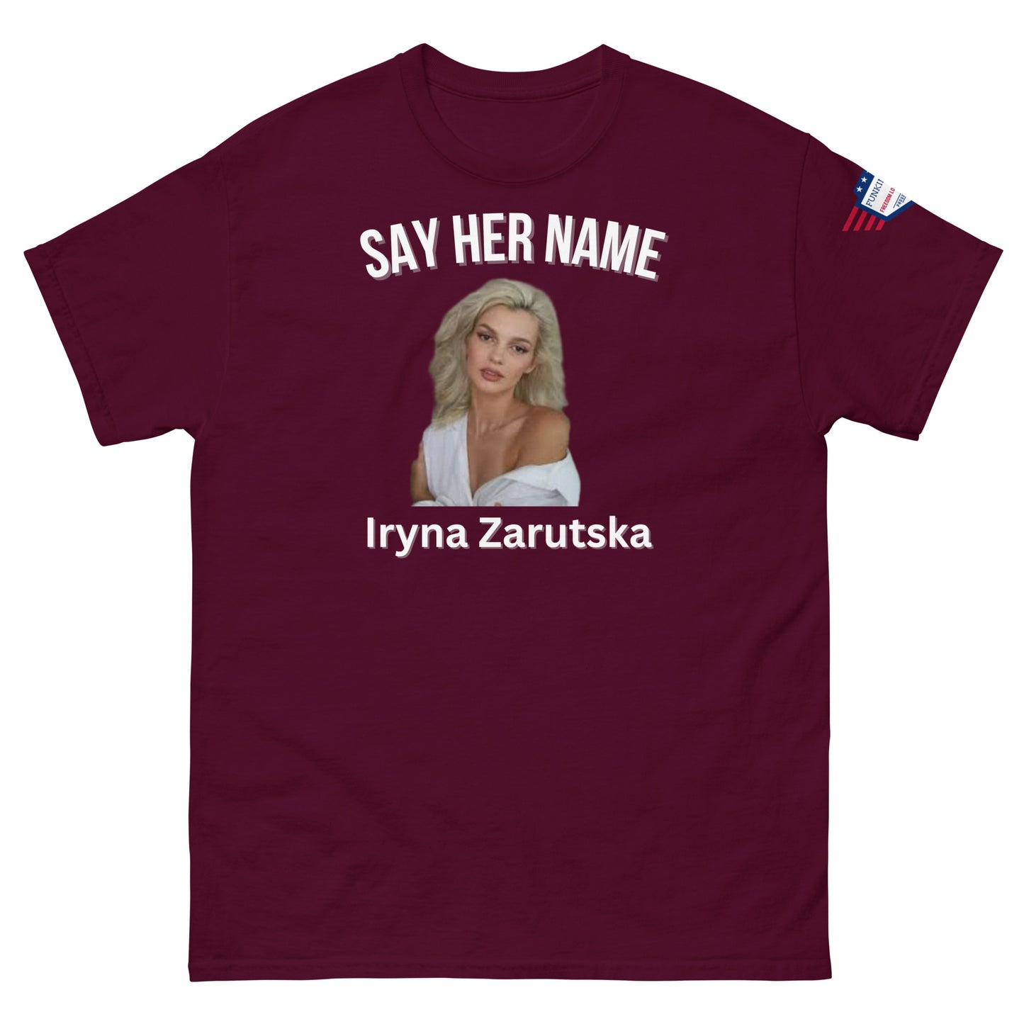 Front view of maroon unisex meme tee: "SAY HER NAME" over blonde Iryna Zarzutska portrait, name below, American flag patch