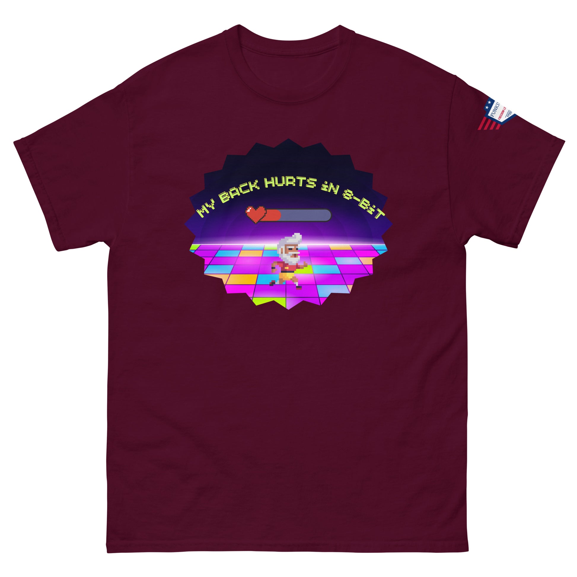 Front view of maroon tee showing "My back hurts so bad" progress bar, 80s chef dancer on colorful floor amid neon starburst, flag patch