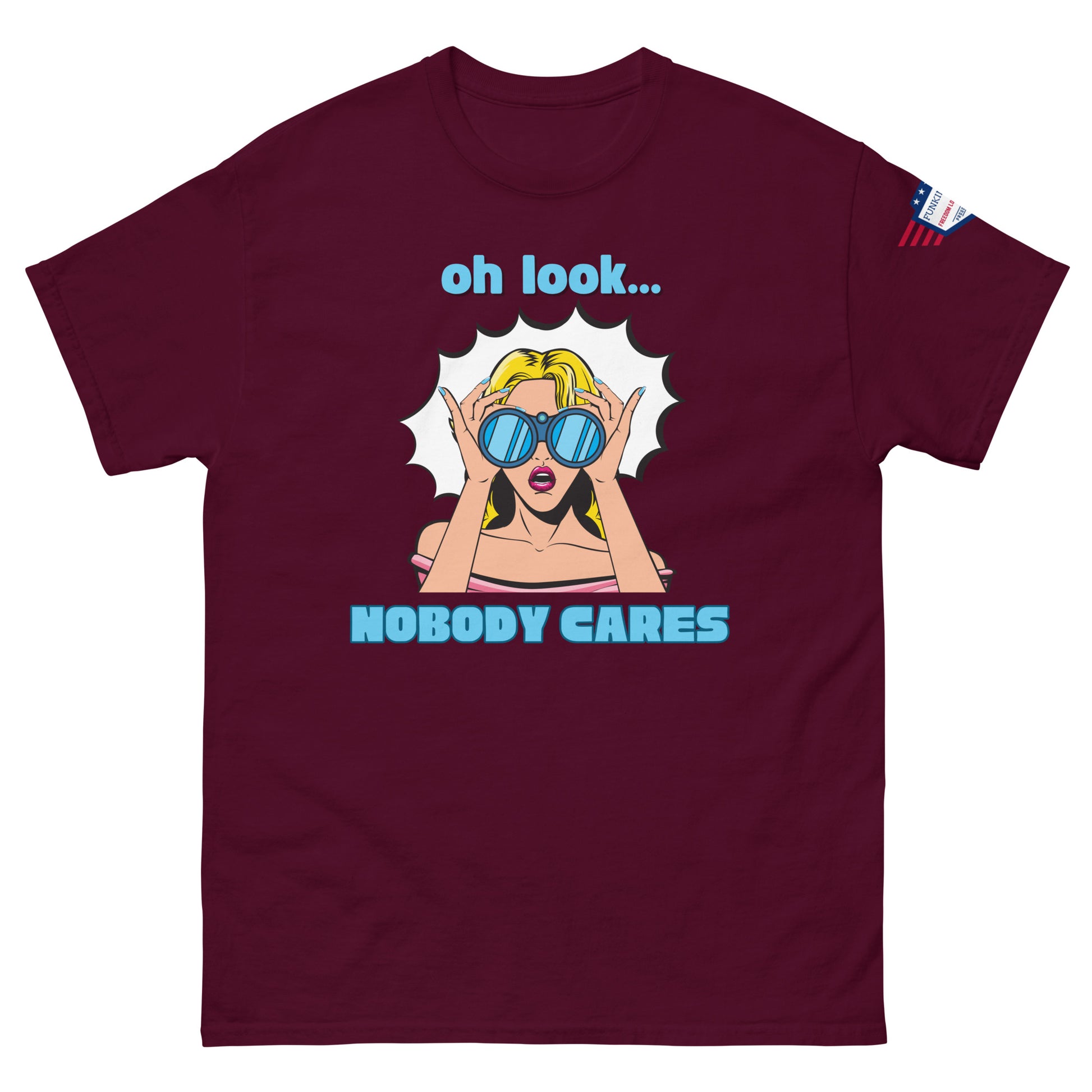 Front view of maroon unisex t-shirt showing "oh look... NOBODY CARES" comic-style blonde bombshell, flag on sleeve