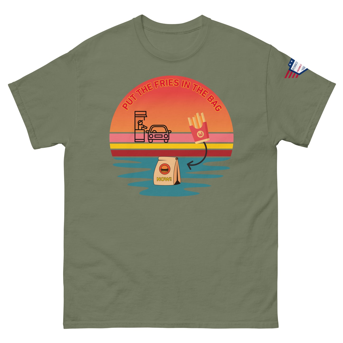Front view of olive green T-shirt with "PUT THE FRIES IN THE BAG" sunset drive-thru print, McD bag, fries and US flag patch