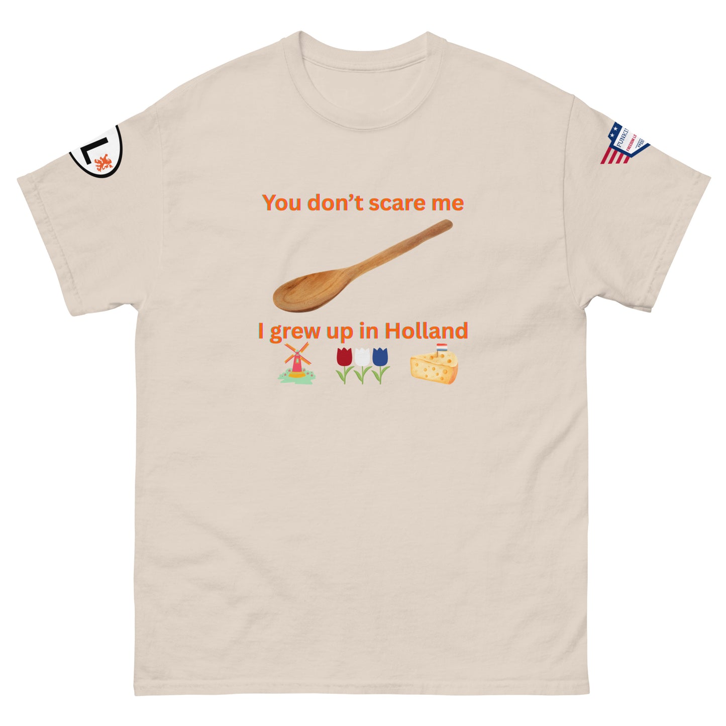 Front view of beige unisex tee with orange "You don't scare me, I grew up in Holland", spoon, windmill, tulips & cheese emojis