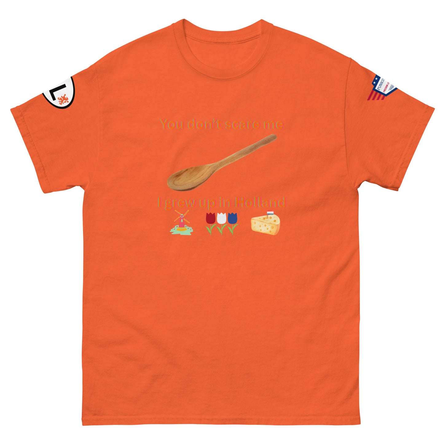 Front view of orange unisex tee with "You don't scare me, I grew up in Holland" text, wooden spoon, Dutch icons: windmill, tulips, cheese