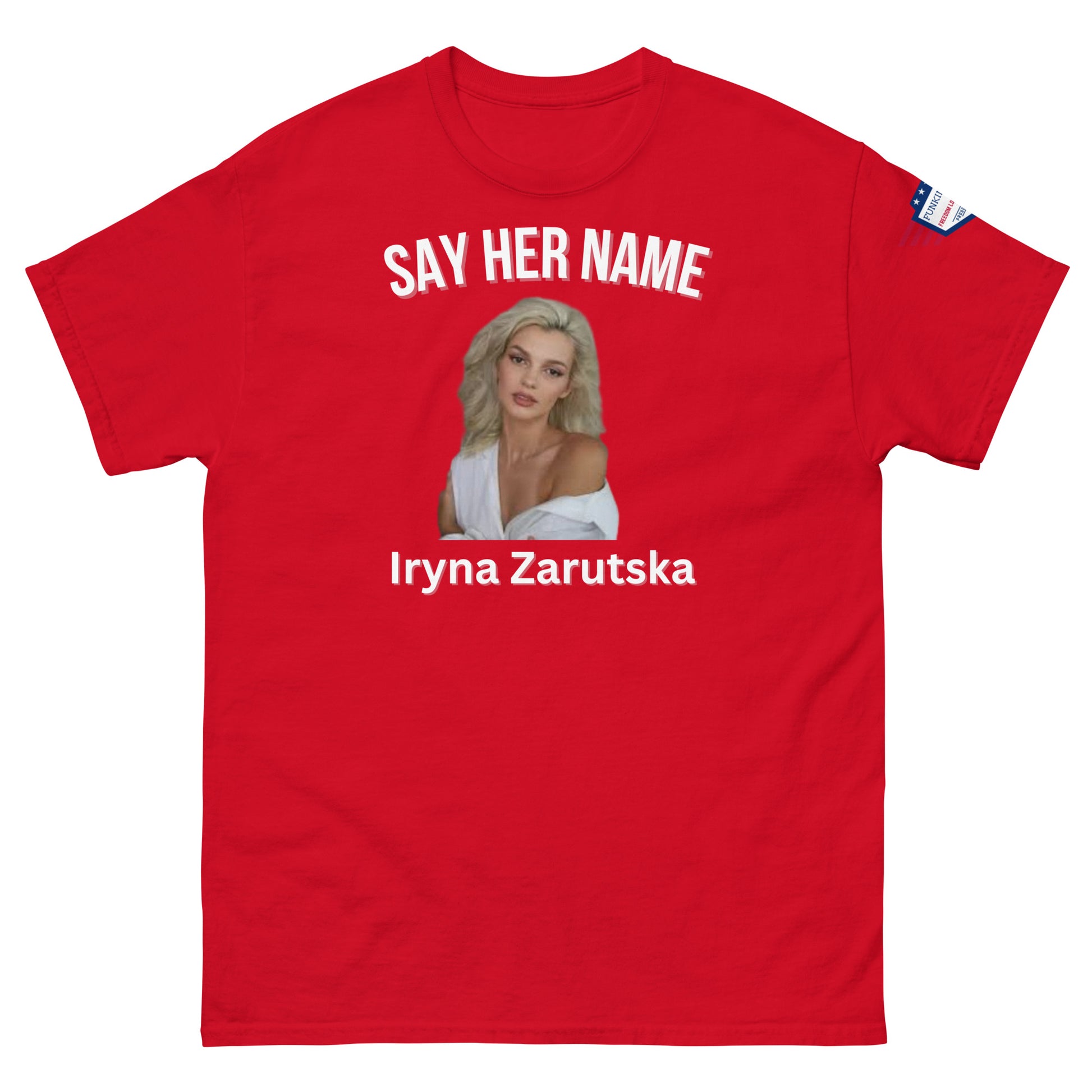 Front view of red meme tee: "SAY HER NAME" arching over Iryna Zarzutska's portrait, her name below, American flag patch