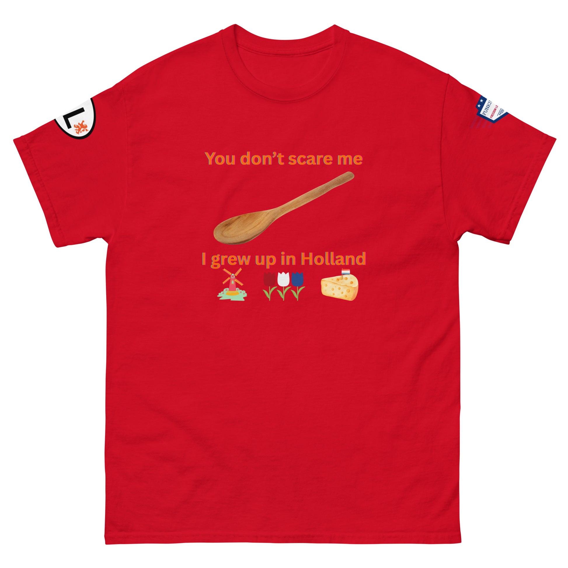 Front view of red unisex tee featuring "You don't scare me, I grew up in Holland" orange print with spoon, windmill, tulips, cheese